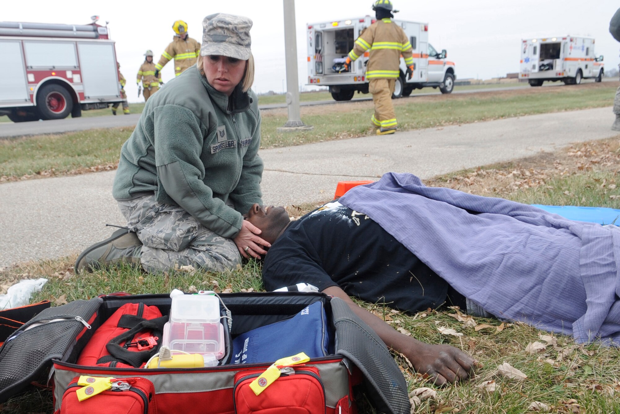 WHITEMAN AIR FORCE BASE, MO—Tech Sgt Jennifer Sponseller, 509th Medical Operations Squadron, maintains cervical spine precautions on Tech Sgt Ronnie McGee, Jr., 509th MDOS, during a  motor vehicle accident exercise at Whiteman Air Force Base, Mo., Nov. 21, 2014.  The purpose of the training was to improve response time and treatment for victims, as well as coordinate patient transport with community partners. The 509th Medical Group, 509th CES Firefighters, Johnson County Ambulance District, and Life Flight participated in the exercise. (U.S. Air Force photo by Staff Sgt. Alexandra M. Boutte/Released)