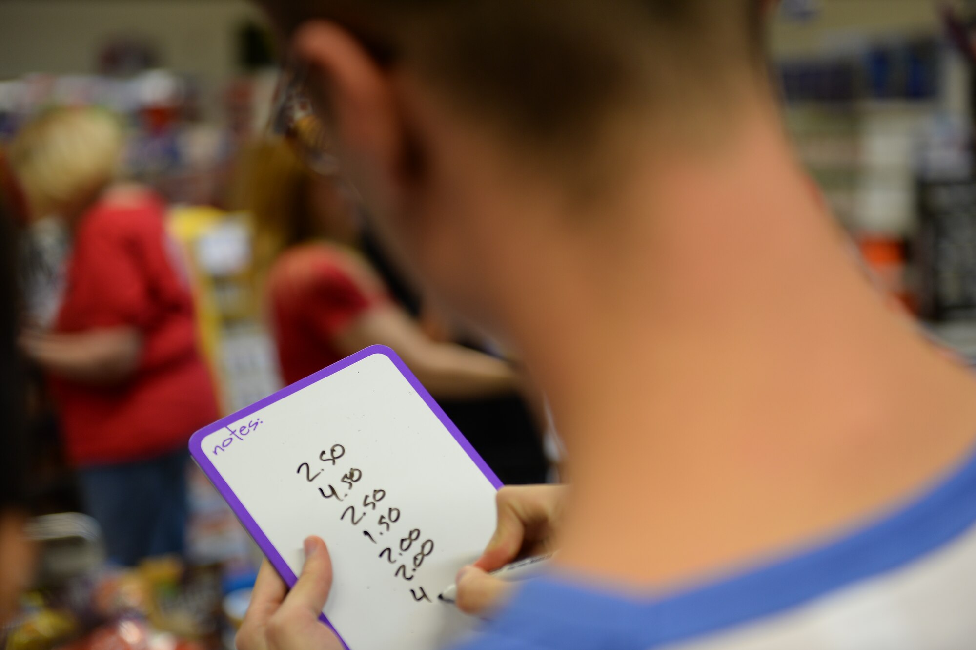 U.S. Air Force Senior Airman Andres Gomez, a 52nd Aerospace Medical Squadron bio-environmental engineering technician, calculates prices of items in his cart during the Commissary Sweep Nov. 20, 2014, at the base commissary. The Spangdahlem Spouses and Enlisted Members Club sponsored the free event with funds collected from the Spring Bazaar. (U.S. Air Force photo by Airman 1st Class Dylan Nuckolls/Released)