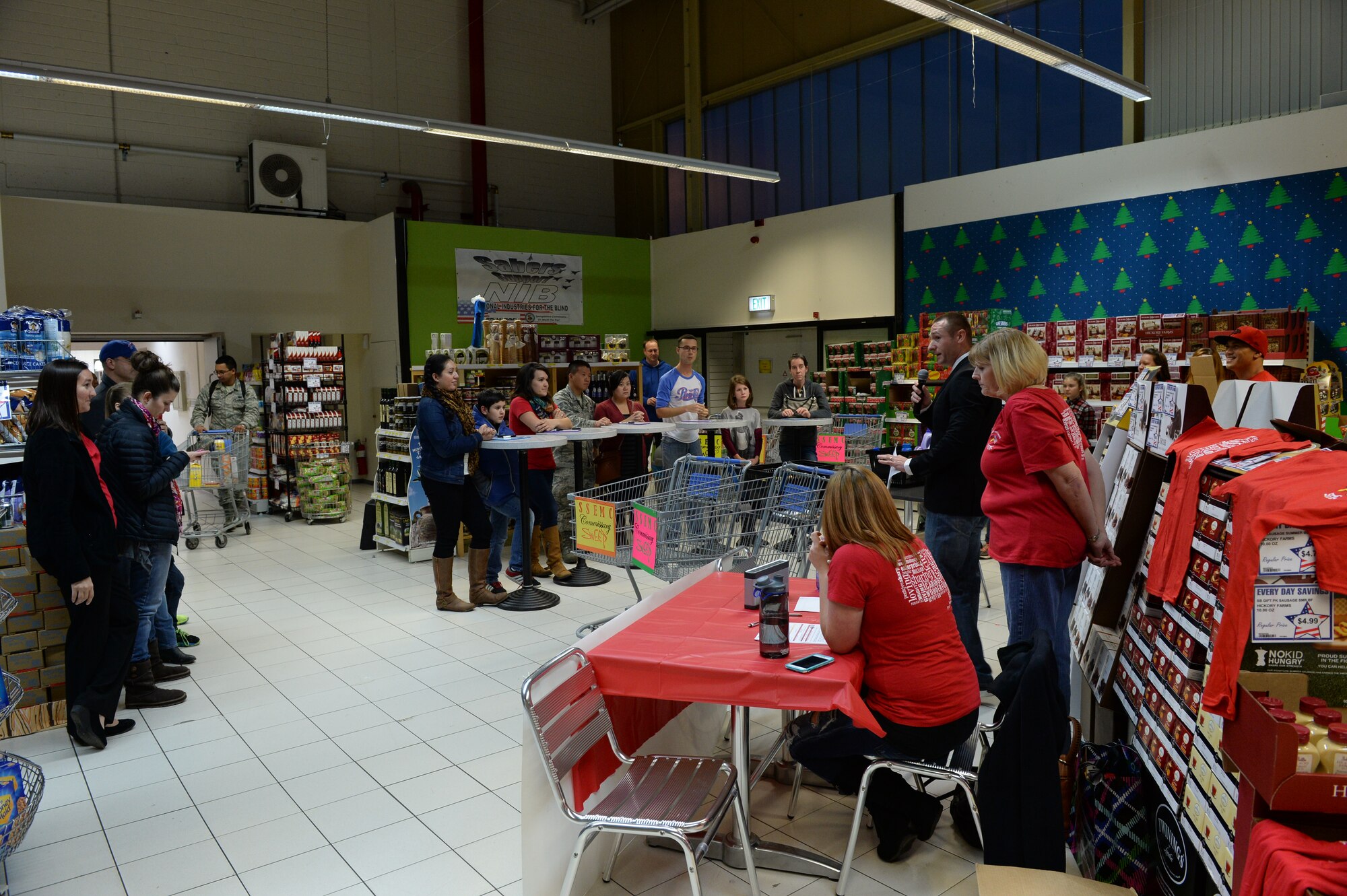 Spectators watch as participants compete in the Commissary Sweep Nov. 20, 2014, at the base commissary. Competitors crunched numbers and solved riddles in a race against time during the event. (U.S. Air Force photo by Airman 1st Class Dylan Nuckolls/Released)