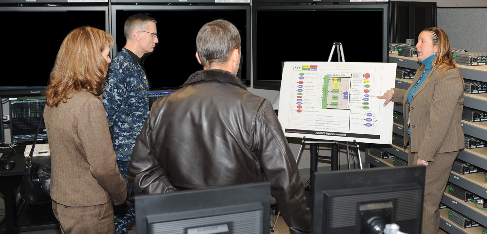 Carolyn Holguin (left) briefs details concerning the Aviation Data Management and Control System (ADMACS) to Rear Adm. Dean Peters, commander, Naval Air Warfare Center Aircraft Division during an orientation visit to the engineering labs at Joint Base McGuire-Dix-Lakehurst, N.J., Nov. 20, 2014. (Courtesy photo)