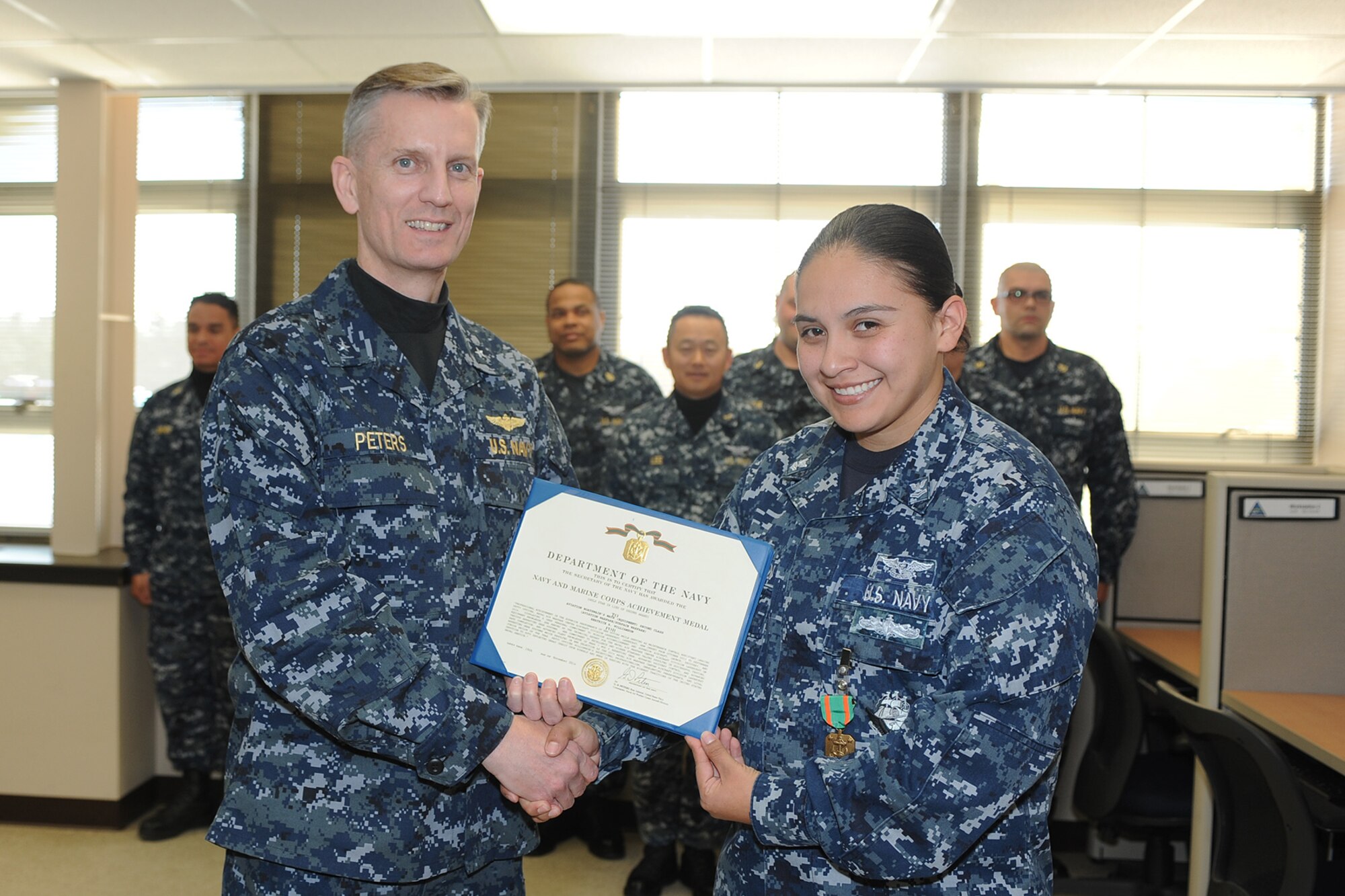 Rear Adm. Dean Peters, commander, Naval Air Warfare Center Aircraft Division presents the Navy/Marine Corps Achievement medal to Petty Officer 2nd Class, ABE2, Beatrice Williamson during a visit to NAWCAD Lakehurst at Joint Base McGuire-Dix-Lakehurst, N.J., Nov. 20, 2014. (Courtesy photo)