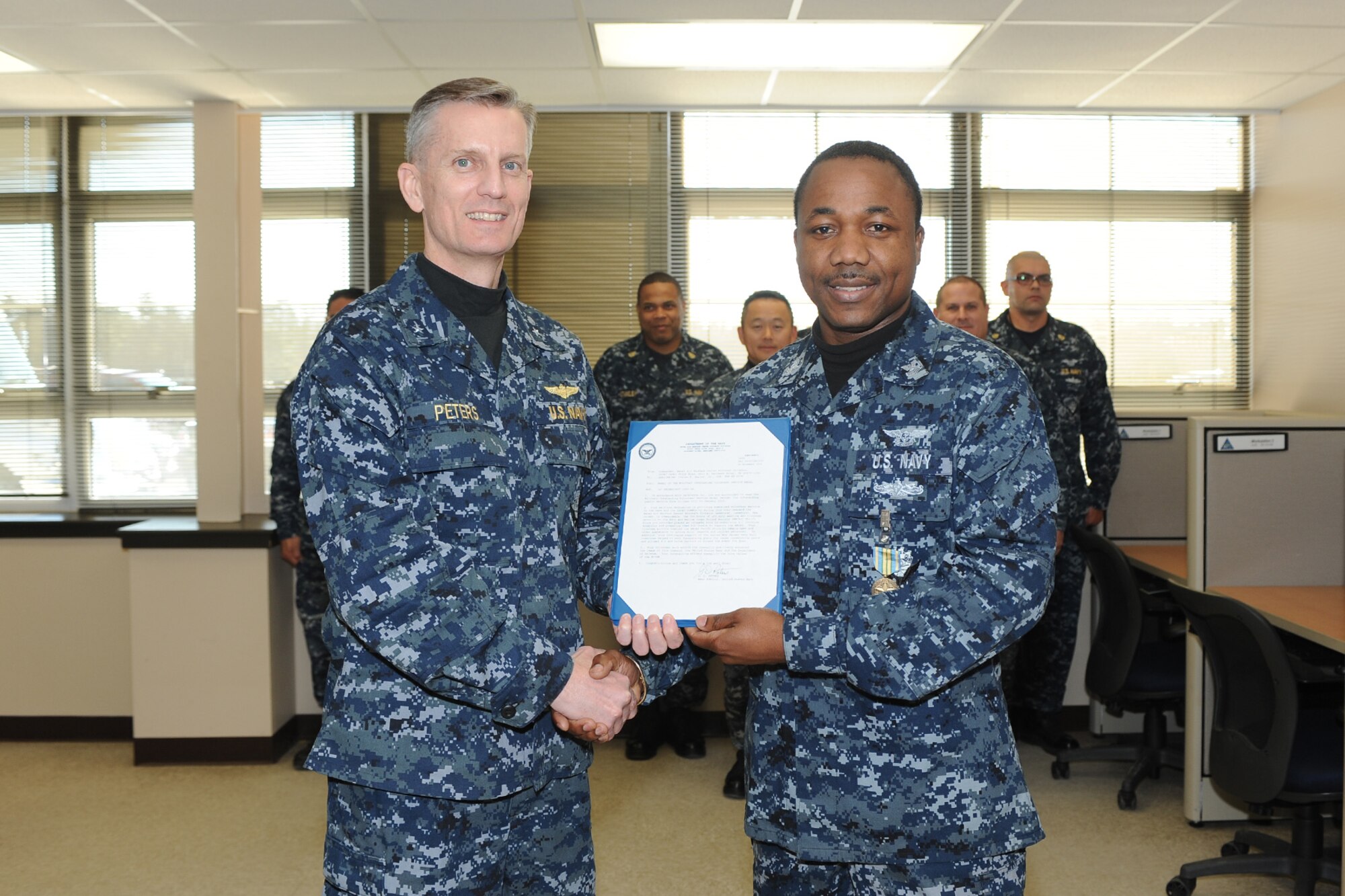 Rear Adm. Dean Peters, commander, NAWCAD presents the Outstanding Volunteer Service medal to Petty Officer 1st Class, ABE1 Ivelaw Sealey during a visit to Joint Base McGuire-Dix-Lakehurst, N.J., Nov. 20, 2014. (Courtesy photo)