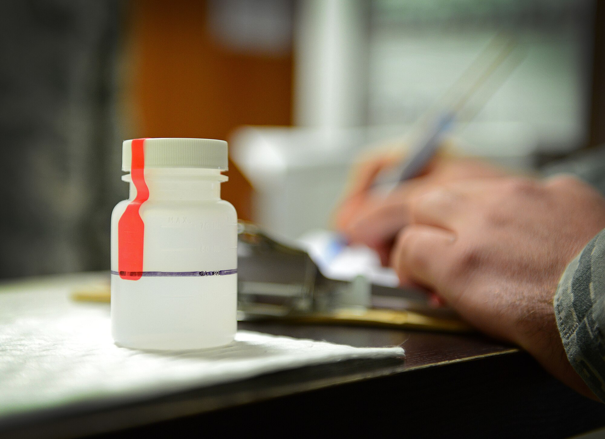 A 31st Fighter Wing Airman finishes a urinalysis test, Nov. 26, 2014, at Aviano Air Base, Italy. The Drug Demand Reduction Program, a program that deters the use of illegal substances to better ensure service members are capable of supporting the mission, uses randomly-selected drug tests called sweeps to help eliminate drug abuse throughout the military. (U.S. Air Force photo/Senior Airman Matthew Lotz)