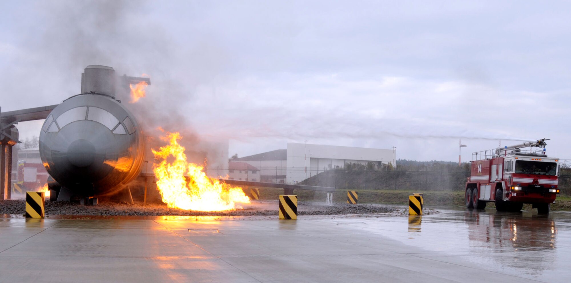 Brig. Gen. Patrick X. Mordente, 86th Airlift Wing commander, rides along as a fire engine belonging to the 86th Civil Engineer Fire Department puts out a fire on a live fire aircraft simulator at Ramstein Air Base, Germany, Nov. 19, 2014. Mordente saw firsthand how the 86th CE firefighters battle building and aircraft fires. (U.S. Air Force photo/Senior Airman Timothy Moore)