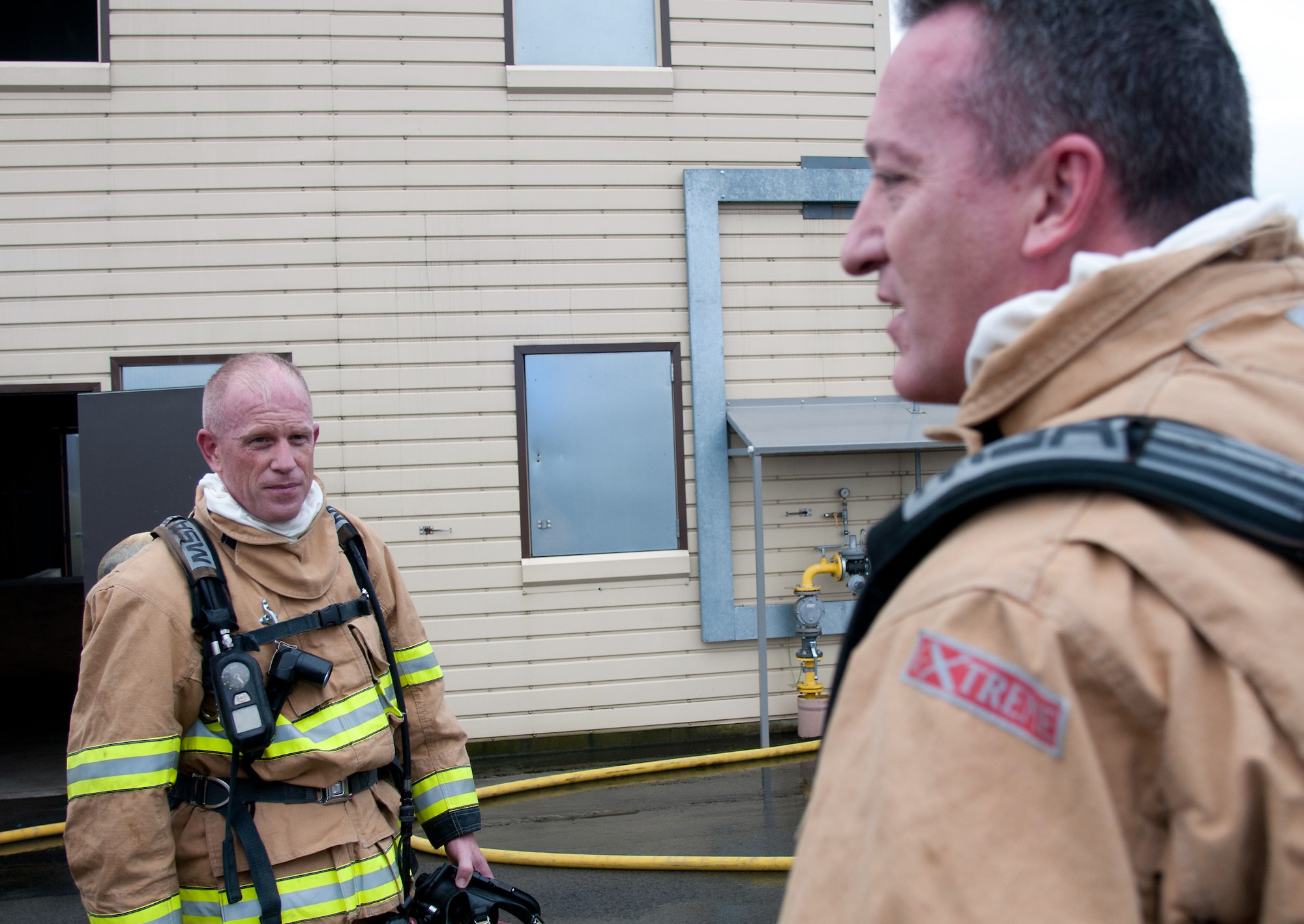 Chief Master Sgt. Frank H. Batten III (left), 86th Airlift Wing command chief, and Brig. Gen. Patrick Mordente, 86th AW commander, discuss their experience after completing a burn house training scenario at Ramstein Air Base, Germany, Nov. 19, 2014. Mordente and Batten participated in the training alongside firefighters from the 86th Civil Engineer Squadron. (U.S. Air Force photo/Senior Airman Timothy Moore)