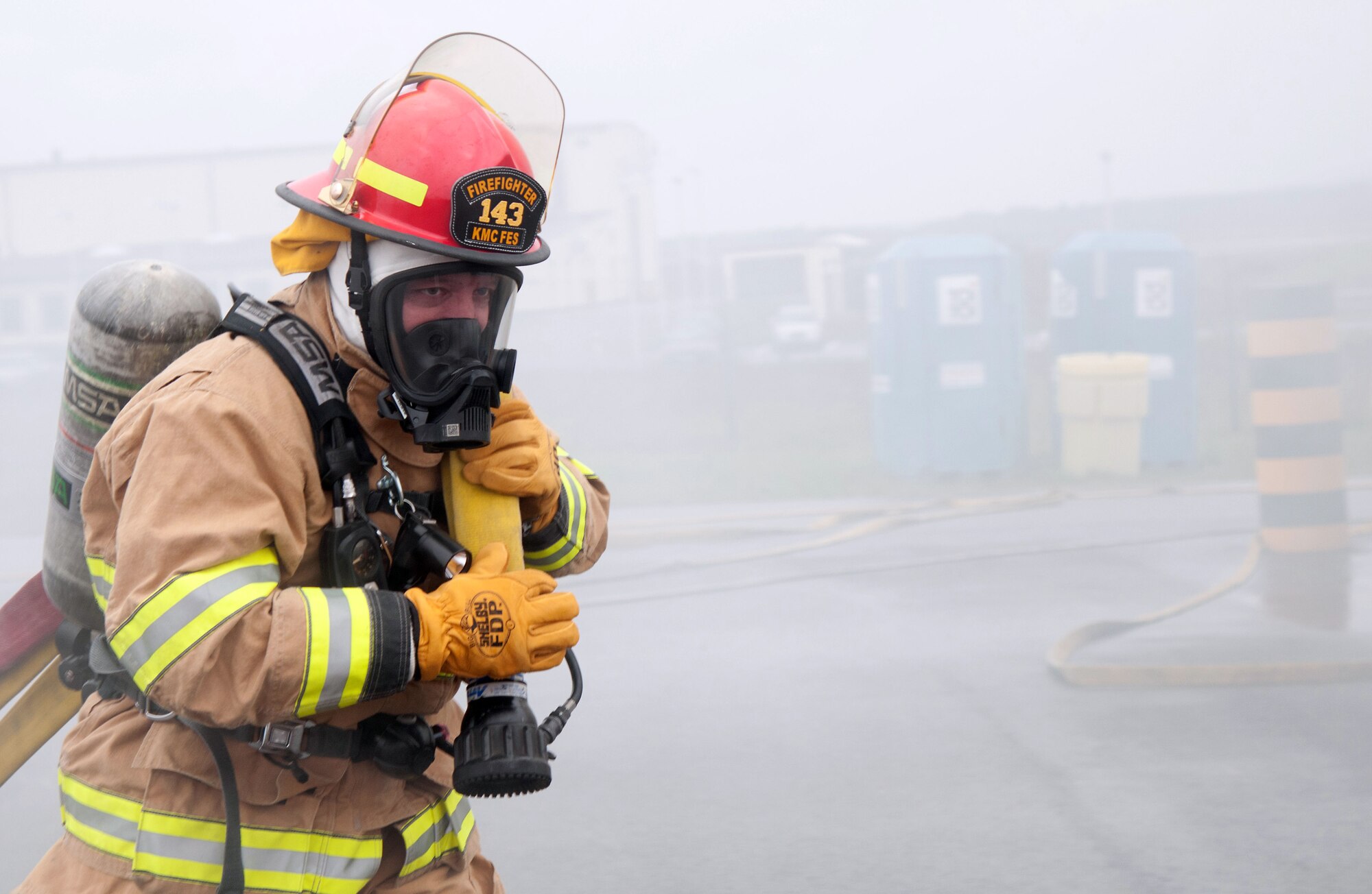 Brig. Gen. Patrick X. Mordente, 86th Airlift Wing commander, pulls a hose from a fire engine at Ramstein Air Base, Germany, Nov. 19, 2014. Mordente participated in a burn house training scenario alongside Chief Master Sgt. Frank H. Batten III, 86th AW command chief, and firefighters assigned to the 86th Civil Engineer Squadron. The burn house training allows firefighters to experience going into a live fire in a controlled environment. (U.S. Air Force photo/Senior Airman Timothy Moore)