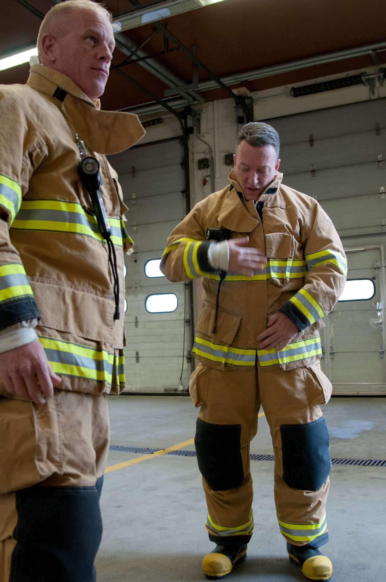 Brig. Gen. Patrick X. Mordente (right), 86th Airlift Wing commander, and Chief Master Sgt. Frank H. Batten III, 86th AW command chief, don safety gear prior to taking part in a burn house training scenario at Ramstein Air Base, Germany, Nov. 19, 2014. Mordente and Batten participated in the scenario alongside firefighters from the 86th Civil Engineer Squadron. The burn house training allows firefighters to experience going into a live fire in a controlled environment. (U.S. Air Force photo/Senior Airman Timothy Moore)