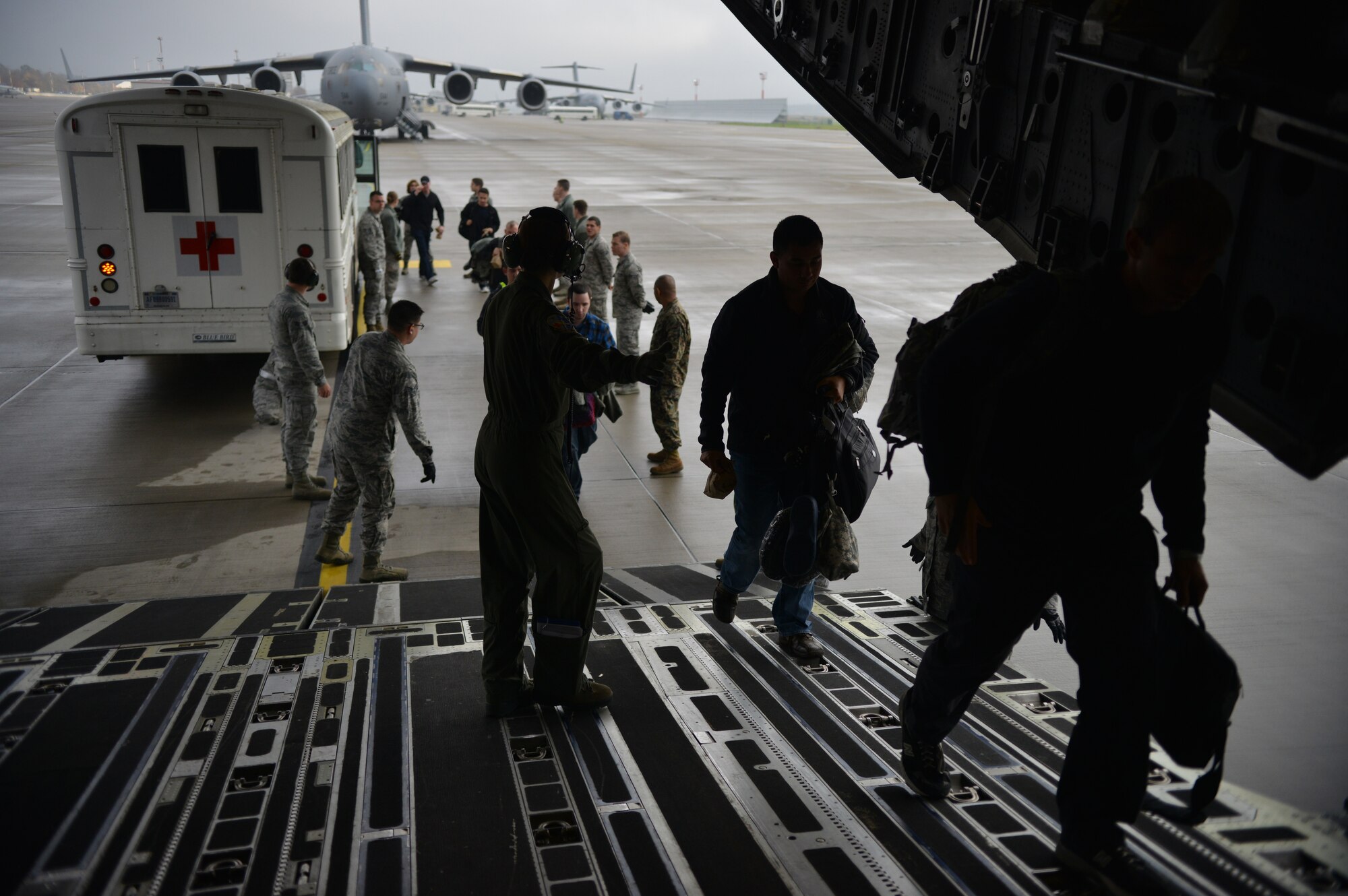 Volunteers and Contingency Aeromedical Staging Facility members assist with loading patients on an aircraft bound for the U.S. on Ramstein Air Base, Germany, Nov. 20, 2014. Airmen at the CASF ensure those injured down range have a smooth transition back home and into the arms of their loved ones. (U.S. Air Force photo/Senior Airman Hailey Haux)
