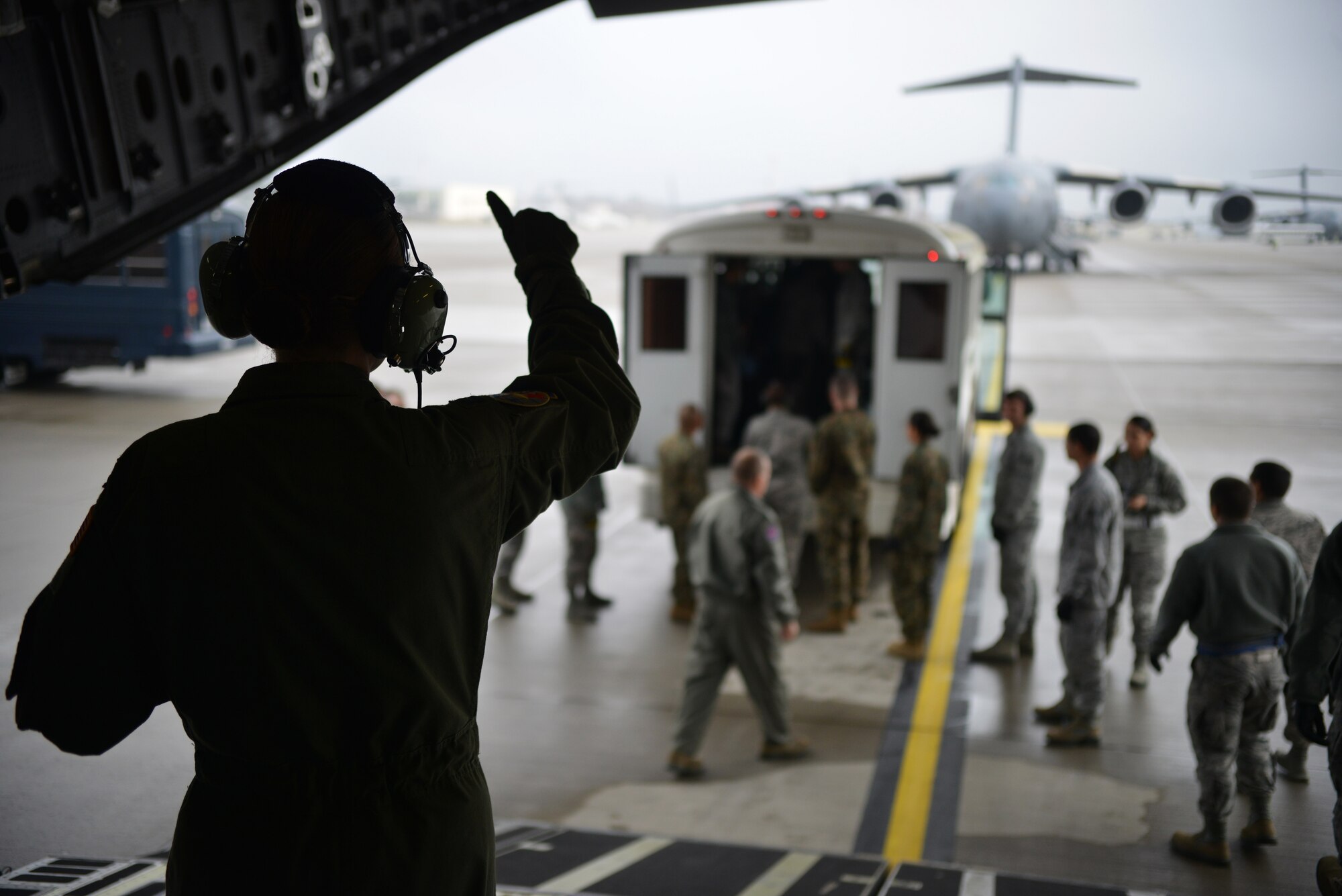 Volunteers and members from the Contingency Aeromedical Staging Facility get the thumbs up to start loading patients on the aircraft on Ramstein Air Base, Germany, Nov. 20, 2014. CASF members wait to get the wheels up call before ending their day. (U.S. Air Force photo/Senior Airman Hailey Haux)
