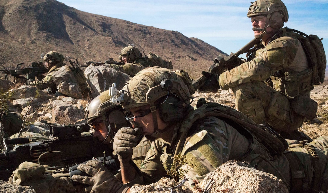 An Army Ranger directs his gun team to provide suppressive fire on an enemy compound during Decisive Action Rotation 15-02 at the National Training Center on Fort Irwin, Calif., Nov. 15, 2014.