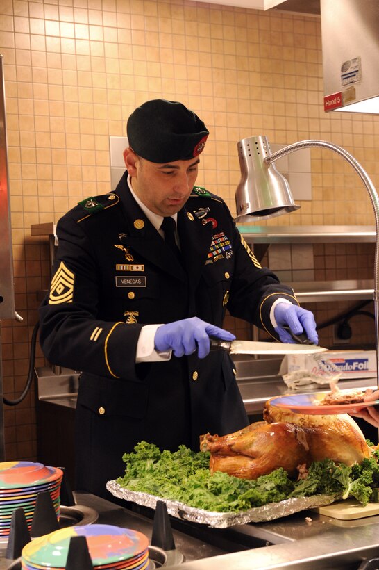 Army 1st Sgt. Venegas carves turkey for service members and their families during a Thanksgiving Day meal on Eglin Air Force Base, Fla., Nov. 24, 2014. Venegas is assigned to the 7th Special Forces Group.