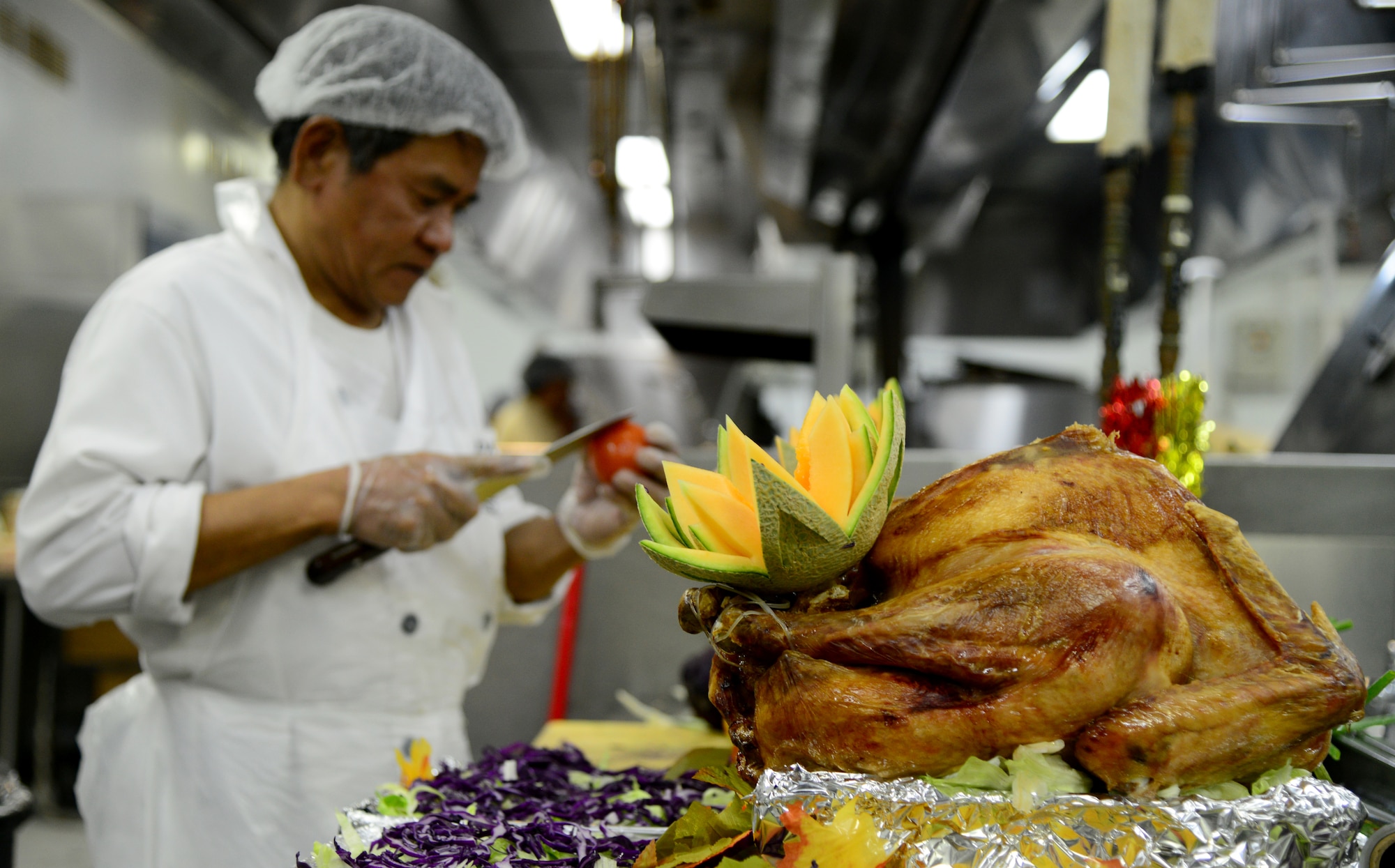 Fruits and vegetables are carved as decorations in preparation of the annual Thanksgiving meal, Nov. 27, 2014, at Al Udeid Air Base, Qatar. Over 400 turkeys were cooked and prepared for deployed servicemembers to enjoy. (U.S. Air Force photo by Senior Airman Kia Atkins)