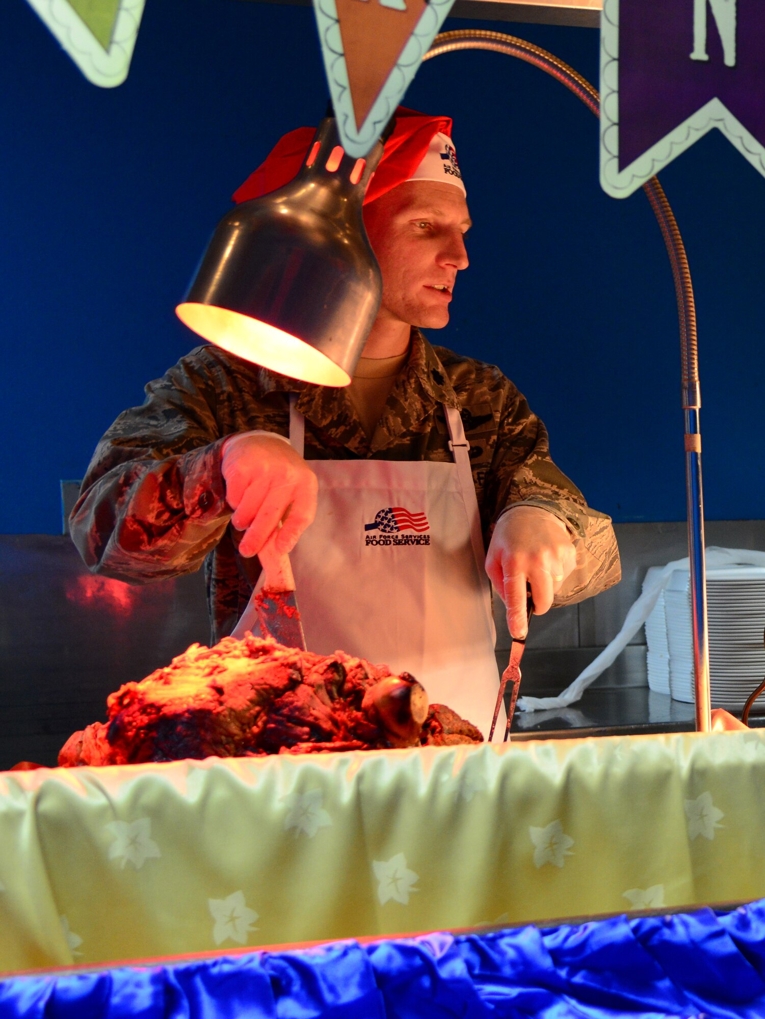U.S. Air Force Lt. Col. Jesse Baker, 8th Expeditionary Air Mobility Squadron commander, carves up roast beef during the annual Thanksgiving meal, Nov. 27, 2014, at Al Udeid Air Base, Qatar. Senior leadership volunteered throughout the day to serve meals to servicemembers at the three base dining facilities. (U.S. Air Force photo by Senior Airman Kia Atkins)