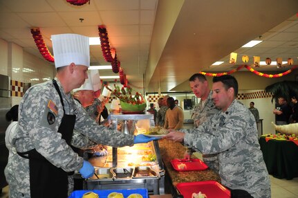 U.S. Army Col. Rollie Miller, Army Support Activity commander, serves a plate of Thanksgiving lunch to a service member of Joint Task Force-Bravo at the Soto Cano Air Base dining facility, Nov. 27, 2014.   JTF-Bravo members were treated to a large Thanksgiving Day meal in celebration of the holiday.  Southern Command senior leaders, as well as leaders from JTF-Bravo, ASA, Army Forces Battalion, Joint Security Forces, 612th Air Base Squadron, 1-228th Aviation Regiment, and Medical Element served the members of the Task Force.  (U.S. Air Force photo by Capt. Connie Dillon)