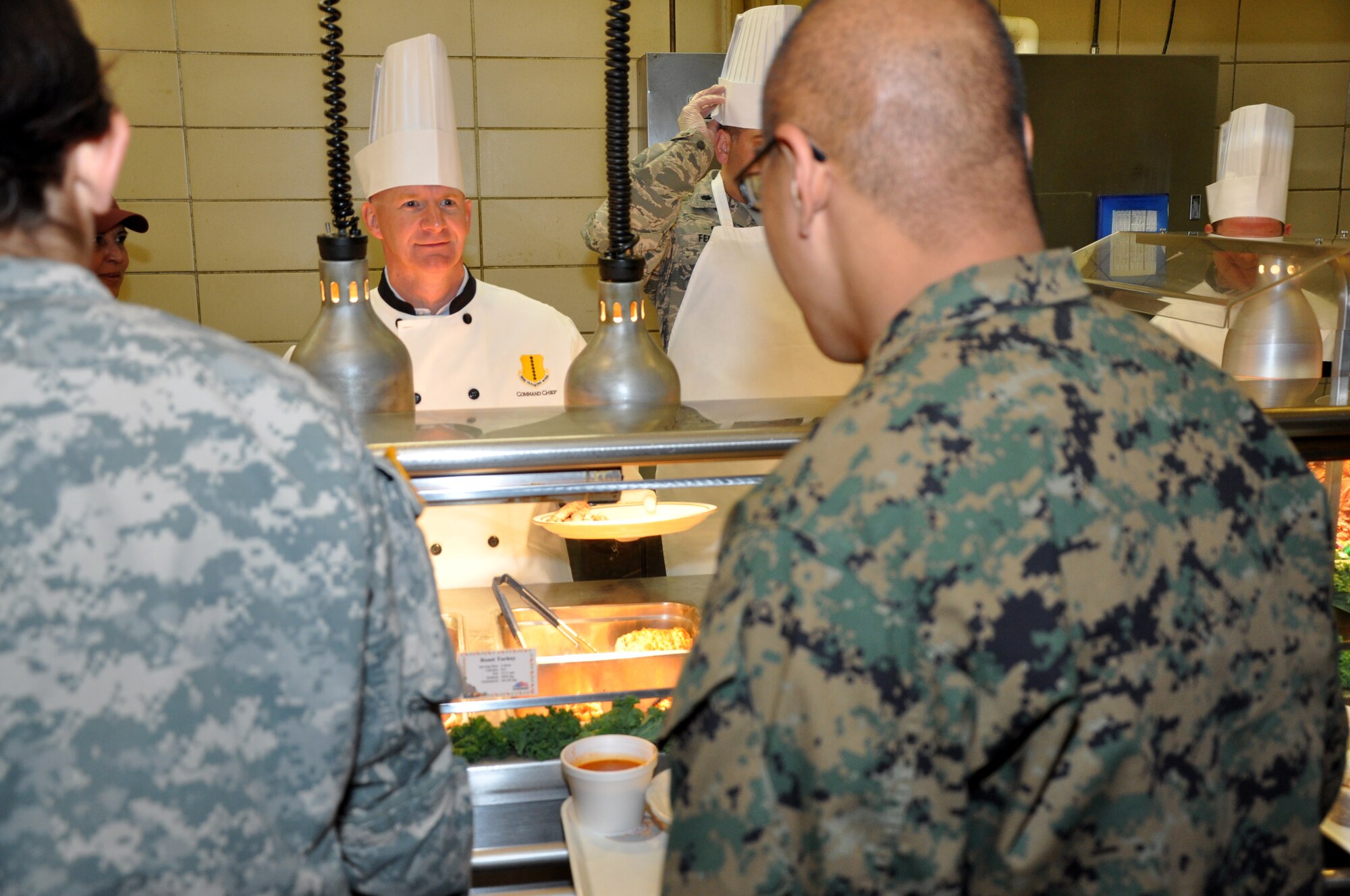 GOODFELLOW AIR FORCE BASE, Texas – Chief Master Sgt. Thomas F. Good, 17th Training Wing Command Chief, asks Lance Cpl. Henry Yau, Marine Corps Detachment student, what he would like to eat for Thanksgiving at the Western Winds Dining Facility Nov. 27. Yau and other service members had a choice of turkey, ham and beef as well as a variety of sides. (U.S. Air Force photo/ Senior Airman Joshua Edwards)