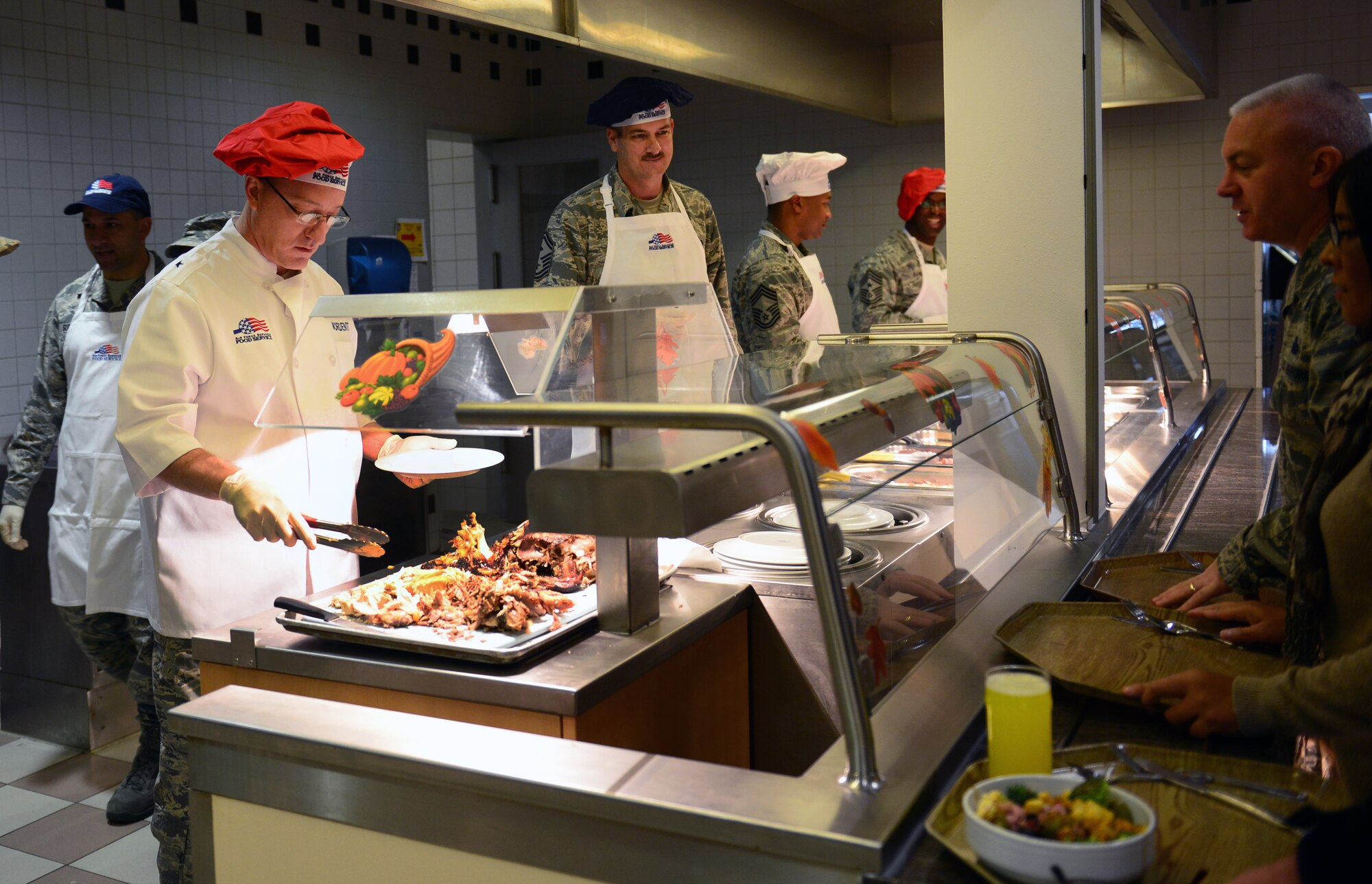 Brig. Gen. Patrick X. Mordente, 86th Airlift Wing commander, serves turkey to KMC members on Thanksgiving Day at the Rheinland Inn Dining Facility on Ramstein Air Base, Germany, Nov. 27, 2014. Mordente, along with several other leaders here, volunteered to help serve a Thanksgiving meal for KMC Airmen and their families. (U.S. Air Force photo/Staff Sgt. Kris Levasseur)