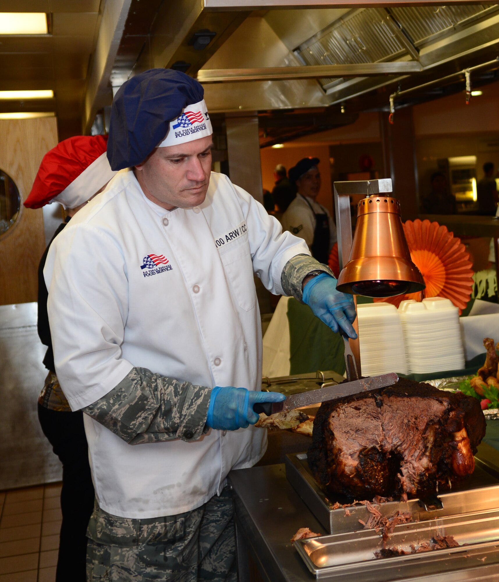 U.S. Air Force Col. Kenneth T. Bibb Jr., 100th Air Refueling Wing commander, carves roast beef for Team Mildenhall members during the Thanksgiving lunch Nov. 27, 2014, at the Gateway Dining Facility on RAF Mildenhall, England. The special meal was prepared in celebration of the American holiday and fed more than 250 members of Team Mildenhall. (U.S. Air Force photo by Airman 1st Class Jonathan Light/Released)