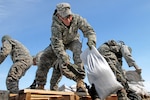 Staff Sgt. Louis Karsnia, a cavalry scout from Headquarters and Headquarters Company, 2nd Combined Arms Battalion, 136th Infantry Regiment, helps distribute sandbags in Moorhead, Minn., as residents continue to fight flooding from the Red River, March 28, 2009.