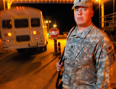 Army Spc. Will Gilroy, a Soldier of the 115th Military Police Company of the Rhode Island National Guard, peers out into a dark road while performing duties at Joint Task Force Guantanamo's access control point Roosevelt, Feb. 29, 2010.