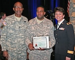 Spc. Damien Hewitt, center, of the 178th Military Police Company of the Georgia National Guard, shows off his U.S. Citizen certificate after taking the oath of citizenship in Atlanta March 9, 2010. He was one of 54 who became naturalized citizens at the 2010 Diversity Conference. On Hewitt's left is Command Sgt. Maj. James Nelson of the Georgia Army Guard, and on the right is Brig. Gen. Maria Britt, assistant adjutant general of the Georgia Army Guard.