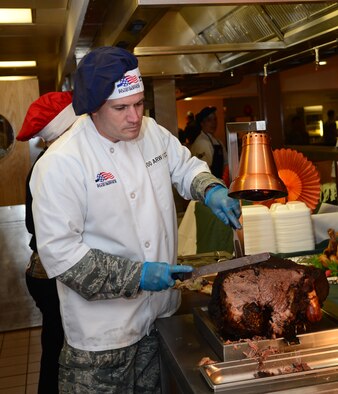 Col. Kenneth T. Bibb Jr. carves roast beef for servicemembers during Thanksgiving lunch Nov. 27, 2014, at the Gateway Dining Facility on RAF Mildenhall, England.  Bibb is the 100th Air Refueling Wing commander. (U.S. Air Force photo/Airman 1st Class Jonathan Light)
