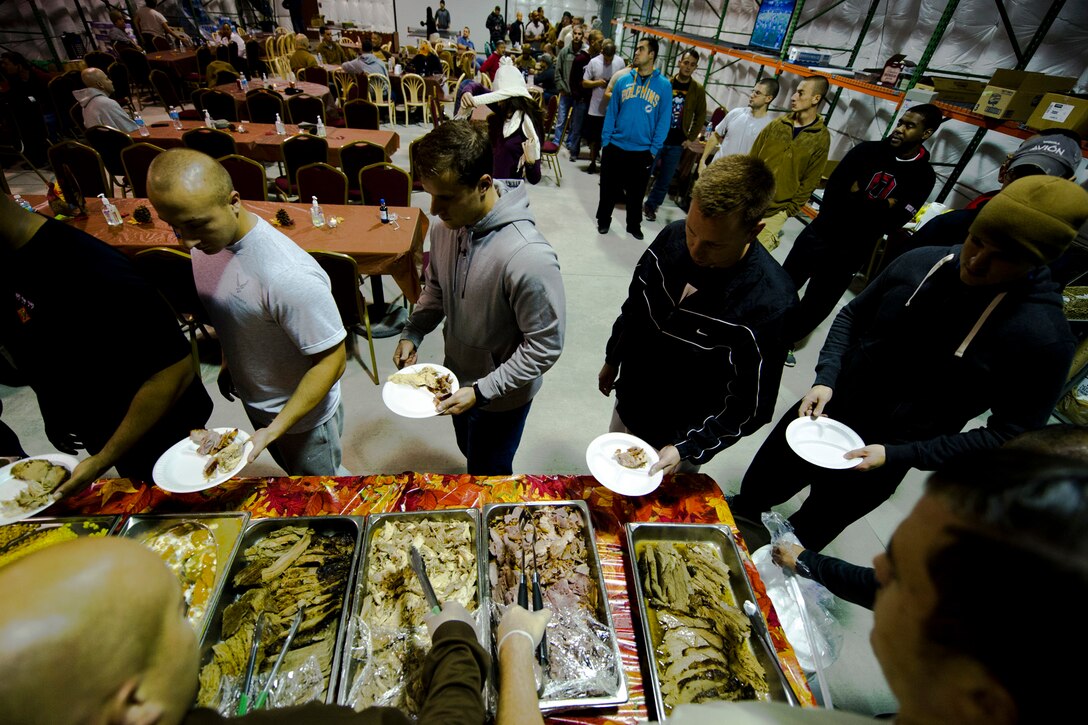 U.S. Service members serve Thanksgiving meals at the Langley Transit Center as part of their Thanksgiving celebration at Joint Base Langley-Eustis, Va., during their controlled monitoring period, Nov. 27, 2014. The members recently returned from Liberia supporting Operation United Assistance, a Department of Defense operation in Liberia to provide logistics, training and engineering support to U.S. Agency for International Development-led efforts to contain the Ebola virus outbreak in West Africa. (U.S. Air Force photo by Staff Sgt. Gustavo Gonzalez/Released)