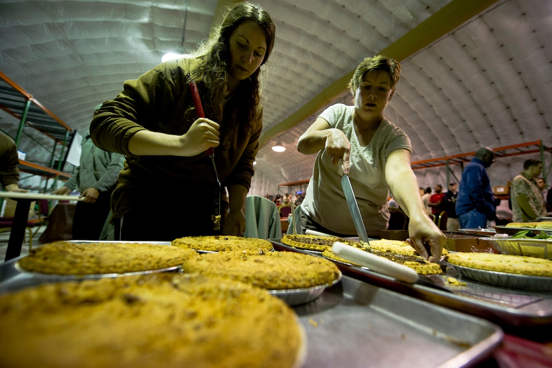 U.S. Air Force 1st Lt. Kathryn Vechik and Col. Joann Frye prepare to serve meals at the Langley Transit Center as part of their Thanksgiving celebration at Joint Base Langley-Eustis, Va., during their controlled monitoring period, Nov. 27, 2014. The members recently returned from Liberia supporting Operation United Assistance, a Department of Defense operation in Liberia to provide logistics, training and engineering support to U.S. Agency for International Development-led efforts to contain the Ebola virus outbreak in West Africa. (U.S. Air Force photo by Staff Sgt. Gustavo Gonzalez/Released)