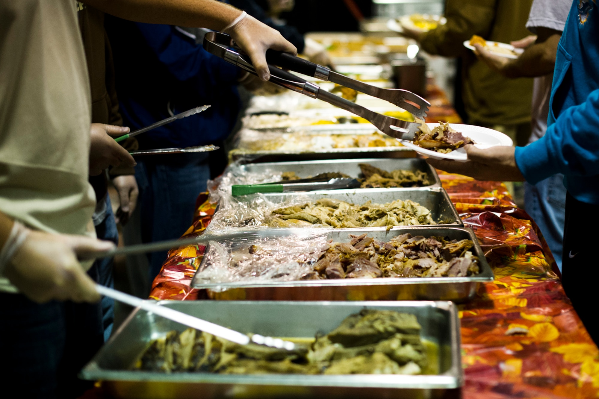 U.S. Service members serve Thanksgiving meals at the Langley Transit Center as part of their Thanksgiving celebration at Joint Base Langley-Eustis, Va., during their controlled monitoring period, Nov. 27, 2014. The members recently returned from Liberia supporting Operation United Assistance, a Department of Defense operation in Liberia to provide logistics, training and engineering support to U.S. Agency for International Development-led efforts to contain the Ebola virus outbreak in West Africa. (U.S. Air Force photo by Staff Sgt. Gustavo Gonzalez/Released)