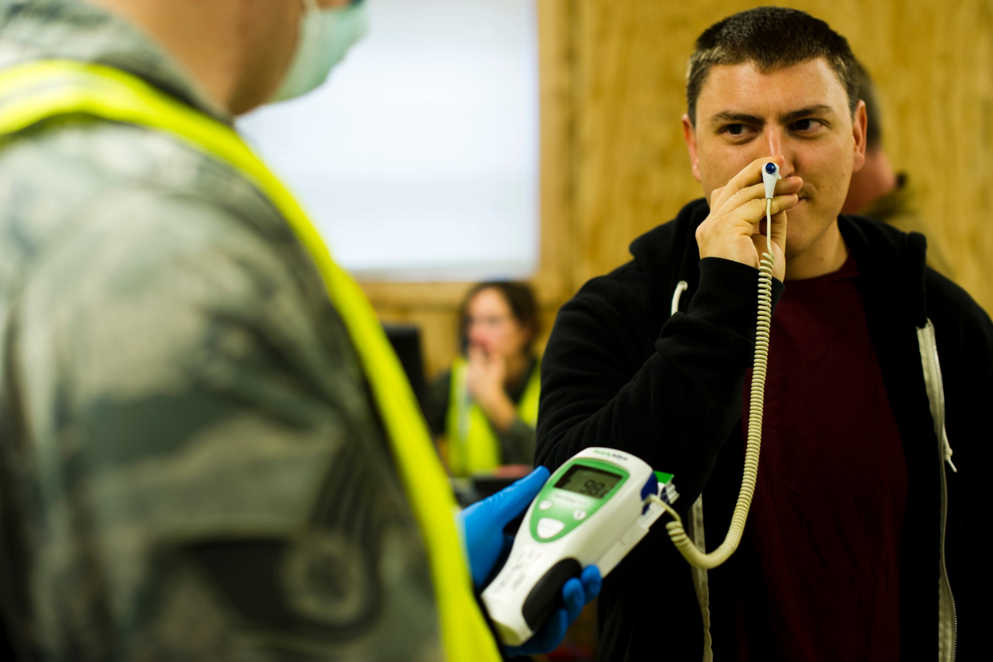 U.S. Air Force Staff Sgt. Zachary Huston assigned to the 621st Contingency Response Wing at Joint Base McGuire-Dix-Lakehurst, N.J., has his temperature taken at the Langley Transit Center before participating in the Thanksgiving celebration at Joint Base Langley-Eustis, Va., during the controlled monitoring period, Nov. 27, 2014. The members recently returned from Liberia supporting Operation United Assistance, a Department of Defense operation in Liberia to provide logistics, training and engineering support to U.S. Agency for International Development-led efforts to contain the Ebola virus outbreak in West Africa. (U.S. Air Force photo by Staff Sgt. Gustavo Gonzalez/Released)