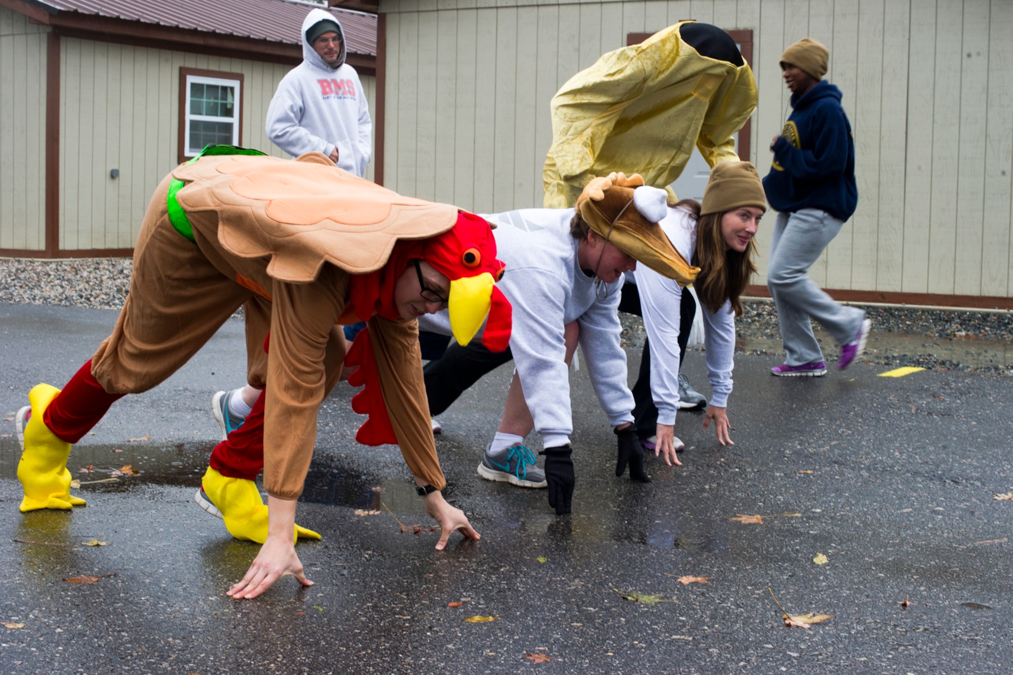Service members get set at the starting line as they take part in the Thanksgiving Turkey Trot 3K run at the Langley Transit Center as part of their Thanksgiving celebration at Joint Base Langley-Eustis, Va., during their controlled monitoring period, Nov. 27, 2014. The members recently returned from Liberia supporting Operation United Assistance, a Department of Defense operation in Liberia to provide logistics, training and engineering support to U.S. Agency for International Development-led efforts to contain the Ebola virus outbreak in West Africa. (U.S. Air Force photo by Staff Sgt. Gustavo Gonzalez/Released)