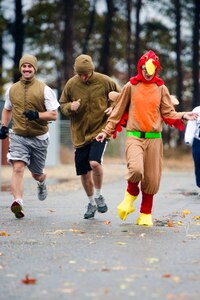 U.S. Air Force Tech. Sgt. Justin Flora, Airman 1st Class Matthew Chiucarello and Maj. Danielle Miller, all assigned to Joint Base McGuire-Dix-Lakehurst, N.J., run as they take part in the Thanksgiving Turkey Trot 3K run at the Langley Transit Center as part of their Thanksgiving celebration during their controlled monitoring period at Joint Base Langley-Eustis, Va., Nov. 27, 2014. The members recently returned from Liberia supporting Operation United Assistance, a Department of Defense operation in Liberia to provide logistics, training and engineering support to U.S. Agency for International Development-led efforts to contain the Ebola virus outbreak in West Africa. (U.S. Air Force photo by Staff Sgt. Gustavo Gonzalez/Released)