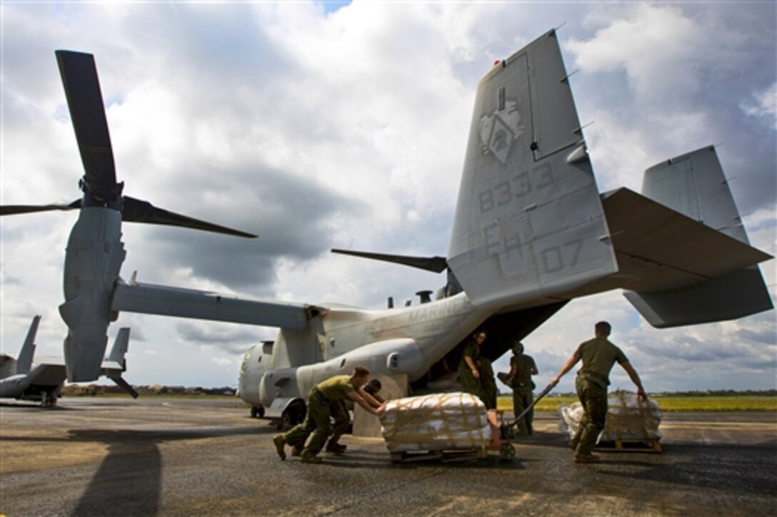 U.S. Marines and sailors prepare to load bags of concrete onto an MV-22B Osprey to help local and international health organizations build Ebola treatment units while supporting Operation United Assistance in Monrovia, Liberia, Nov. 21, 2014.