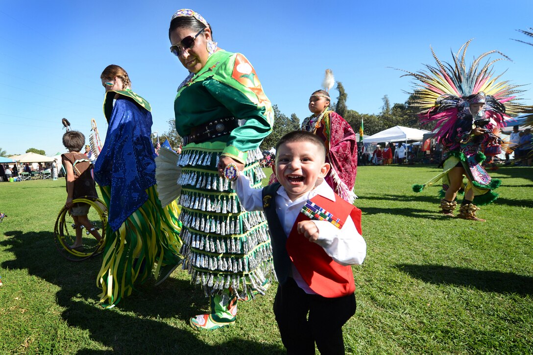 Angelina Alvarez, a Pascua Yaqui tribe member and daughter of a Vietnam veteran, wears jingle dress regalia as she and her 2-year-old son, Pedro, participate in the Native American Veterans Association's annual Veterans Appreciation and Heritage Day Pow Wow in South Gate, Calif., Nov. 8, 2014. Alvarez’s father, a Navy Vietnam veteran and member of SEAL Team 2, received three Purple Hearts, the Navy Cross and the Silver and Bronze stars.
