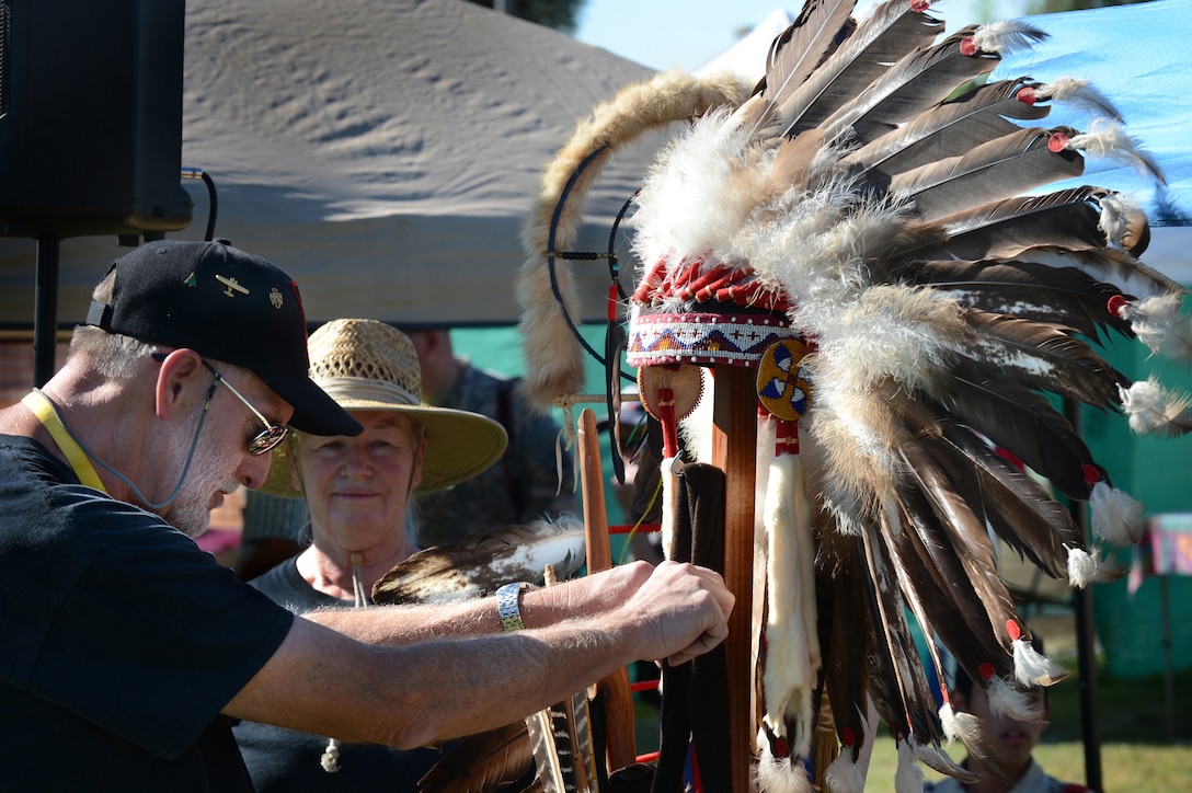 Rick Ussery from the Choctaw Cherokee nation arranges ceremonial regalia of fallen warriors during the Native American Veterans Association's annual Veterans Appreciation and Heritage Day Pow Wow in South Gate, Calif., Nov. 8, 2014.