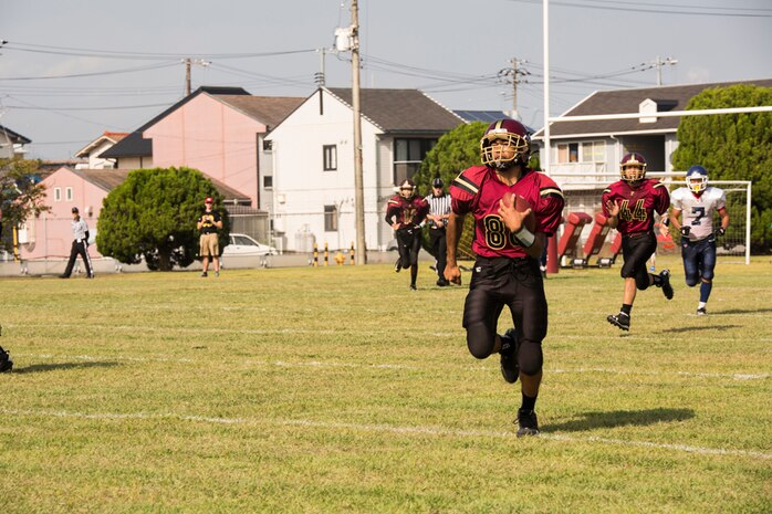 Desmond Moore, Samurai wide receiver and linebacker, runs the ball down the field during Matthew C. Perry High School’s first home game of the season against Sotuku High School, Sept. 27, 2014, aboard Marine Corps Air Station Iwakuni, Japan. After beating the Sotuku Fighting Ducks, the Samurai are 3-0 for the season.
