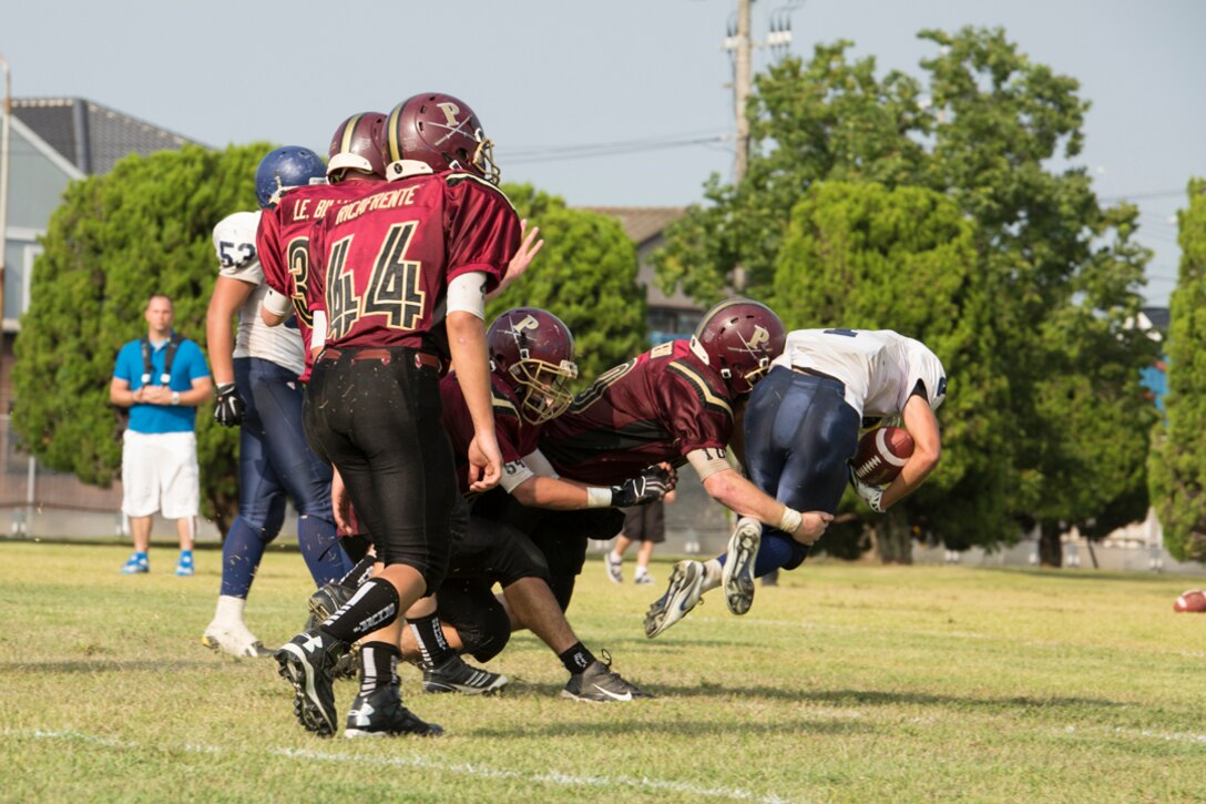 Matthew C. Perry High School football players tackle a player from Sotuku High School during the Samurai’s first home game of the season, Sept. 27, 2014, aboard Marine Corps Air Station Iwakuni, Japan. M. C. Perry brought back high school football in 2012 and this is the Samurai’s first varsity season.