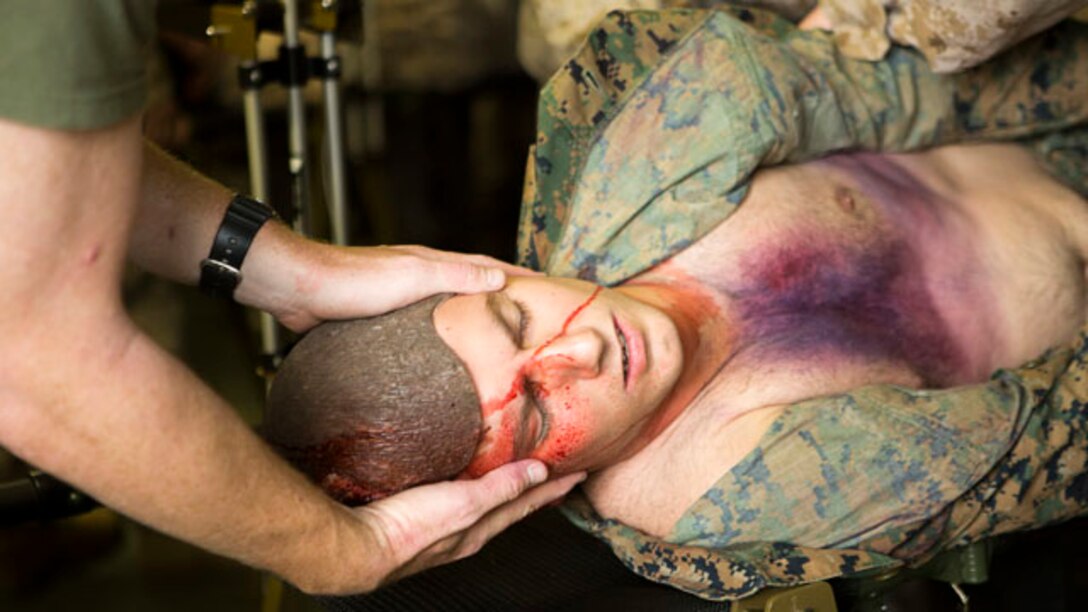 Petty Officer 3rd Class Landon P. Burdette, a Roseburg, Ore., native and corpsman with Bravo Company, 2nd Medical Battalion, 2nd Marine Logistics Group, stabilizes a simulated casualty’s head while he is turned over to check for other injuries during an exercise aboard Marine Corps Base Camp Lejeune, N.C., Sept. 23, 2014.  The unit used makeup on simulated casualties to represent injuries for the corpsmen to diagnose and treat. (U.S. Marine Corps photo by Pfc. Olivia C. McDonald/Released)