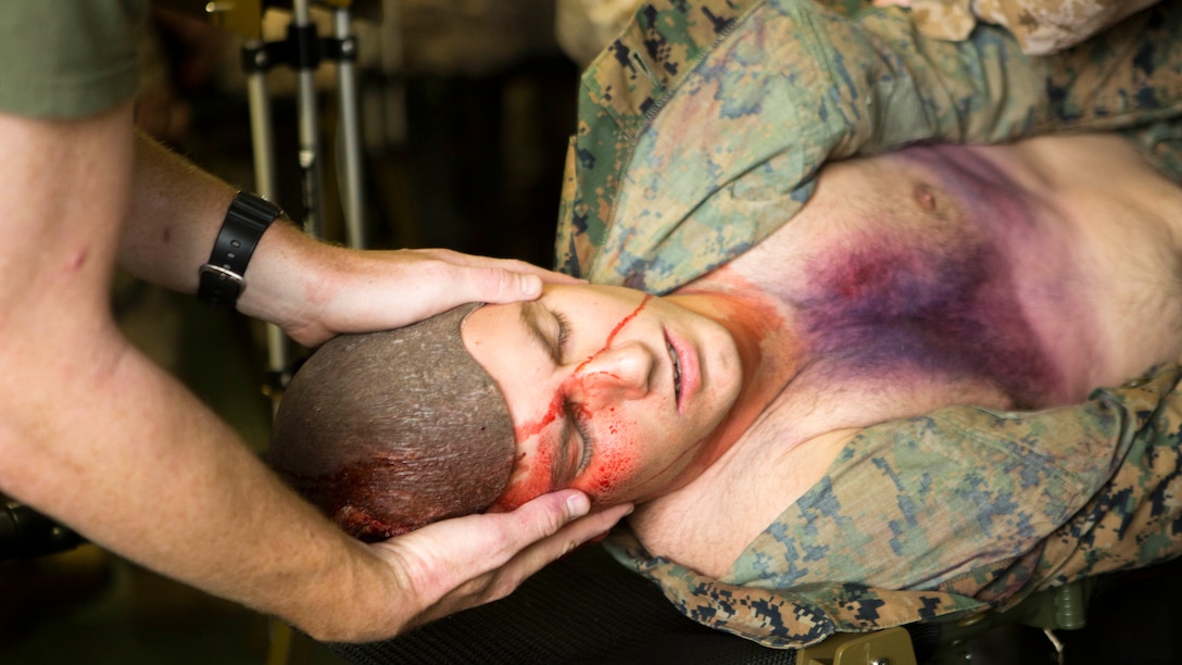 Petty Officer 3rd Class Landon P. Burdette, a Roseburg, Ore., native and corpsman with Bravo Company, 2nd Medical Battalion, 2nd Marine Logistics Group, stabilizes a simulated casualty’s head while he is turned over to check for other injuries during an exercise aboard Marine Corps Base Camp Lejeune, N.C., Sept. 23, 2014.  The unit used makeup on simulated casualties to represent injuries for the corpsmen to diagnose and treat. 