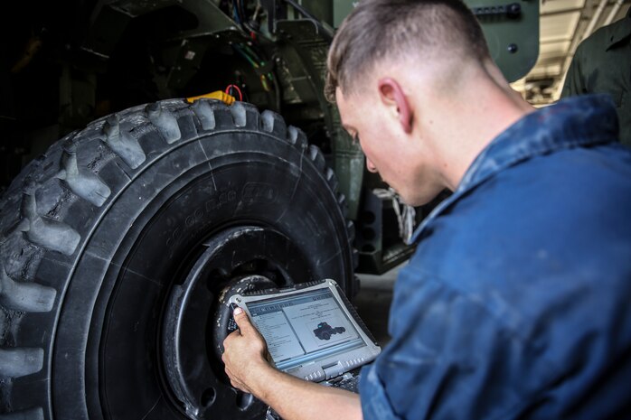 Lance Cpl. Devon Campbell, a motor transportation mechanic with the 24th Marine Expeditionary Unit’s Logistics Combat Element, Combat Logistics Battalion 24, and native of Dothan, Ala., references a ToughBook while troubleshooting the engine of a Medium Tactical Vehicle Replacement, or 7-Ton,at Camp Lejeune, N.C., Sept. 30, 2014. Marines with the unit performed maintenance on vehicles in preparation for Composite Training Unit Exercise, the fourth major pre-deployment exercise in preparation of the deployment at the end of the year.