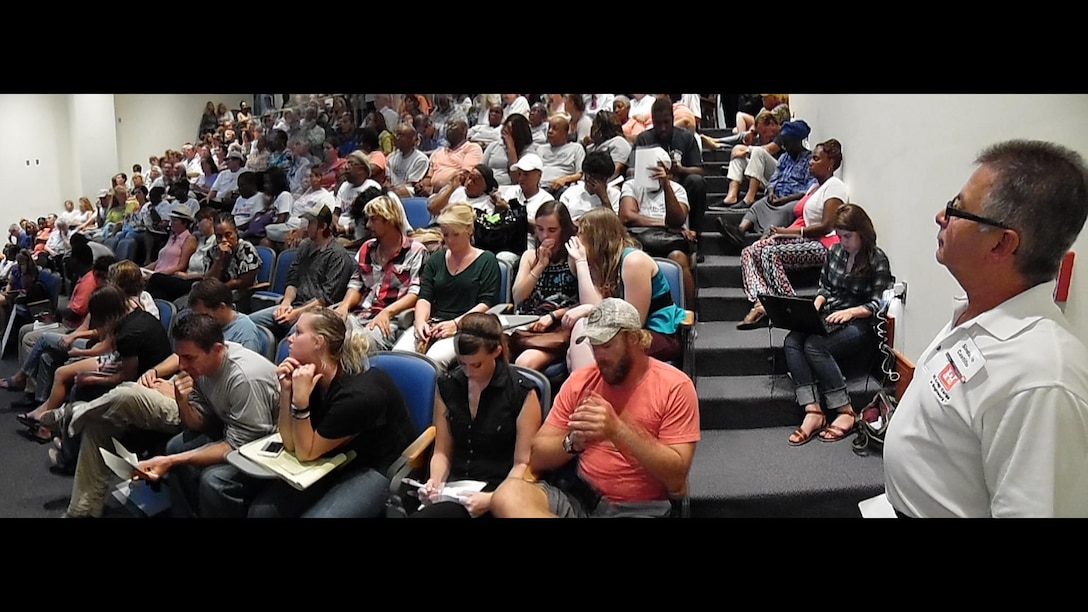 Sindulfo Castillo (right), chief of the Antilles Regulatory Section, watches as members of a standing-room-only crowd await their turn to speak at Regulatory Division's Sept. 25 public meeting to discuss the Coral World Ocean park permit application.