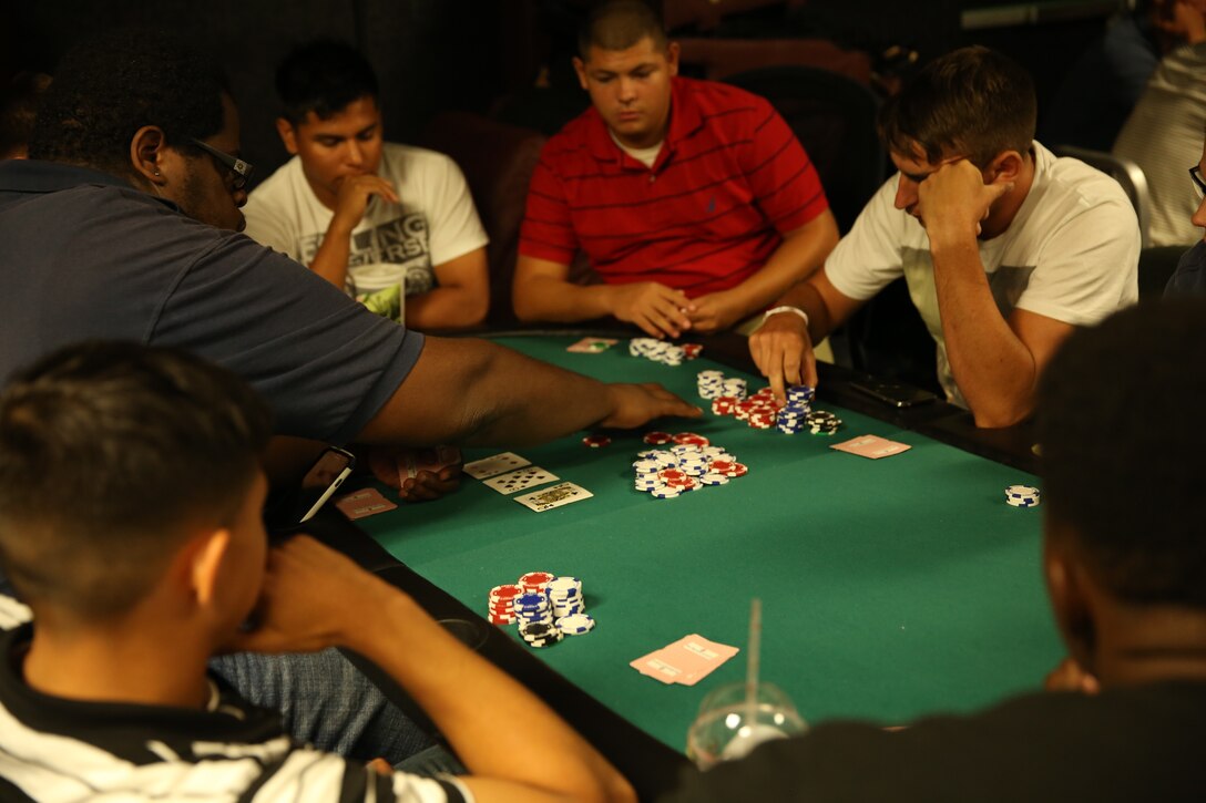 Marines play a hand of Texas Hold’em at The 5th Street Zone, Sept. 26. Players in the game had the option of placing a bet every time a new card is placed on the table, or folding their hand.