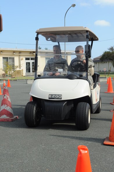 U.S. Air Force Tech. Sgt. Logan McKeown, 35th Fighter Wing NCO in charge of ground safety, and U.S. Air Force Staff Sgt. Miguel Campos, 35th Maintenance Squadron avionics technician, conduct a texting-and-driving-simulation during a distracted driving course on Resilient Airmen Day at Misawa Air Base, Japan, Sept. 29, 2014. The course allowed Airmen to experience the dangers of distracted driving firsthand. (U.S. Air Force photo by Airman Jordyn Rucker)
