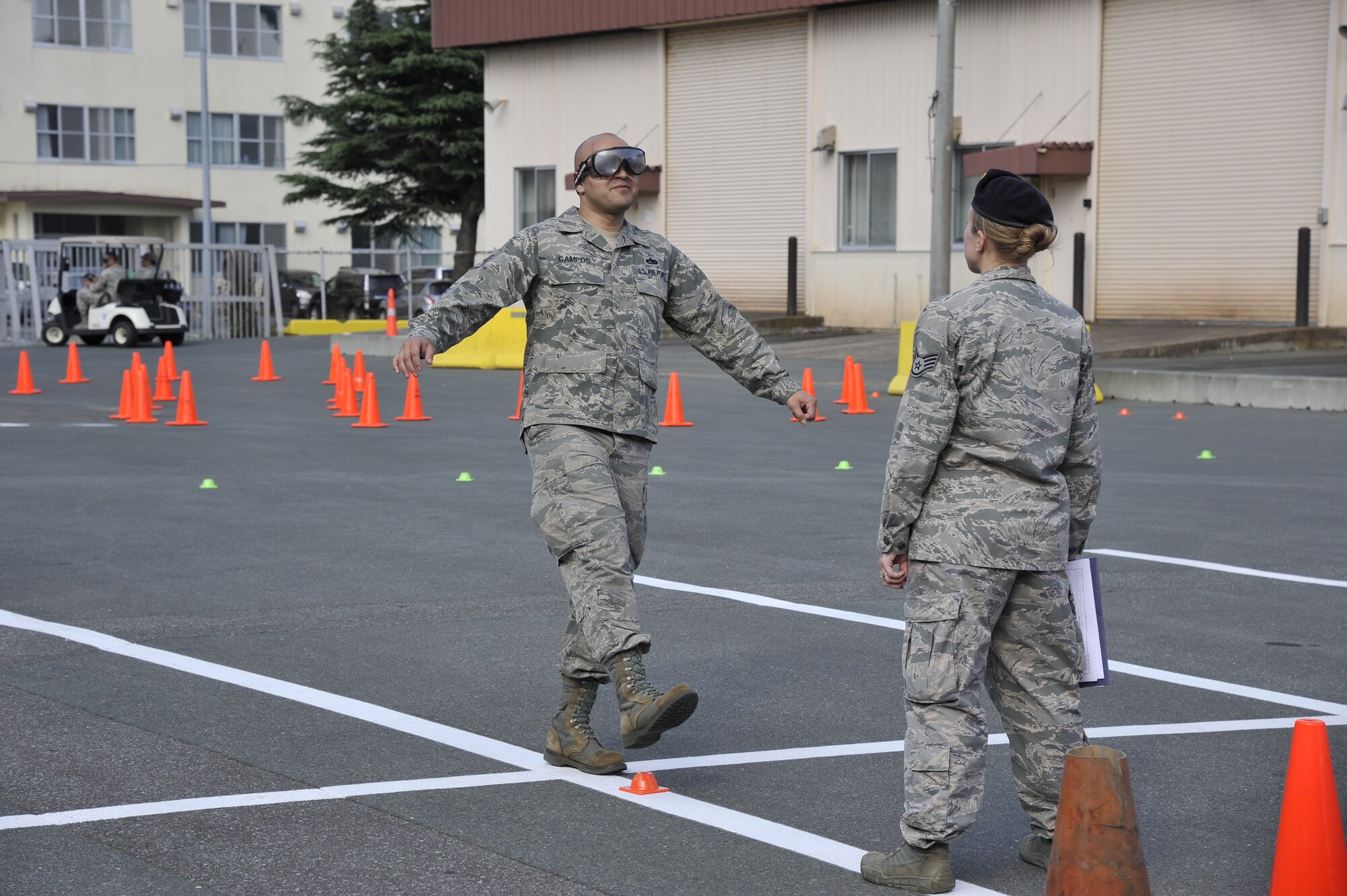U.S. Air Force Staff Sgt. Miguel Campos, 35th Maintenance Squadron avionics technician, performs a sobriety walk as Staff Sgt. Robin Knabe, 35th Security Forces, Investigator, monitors his movement during a driving-while-under-the-influence simulation course on Resilient Airman Day at Misawa Air Base, Japan, Sept 29, 2014. Airmen were encouraged to participate in the course, which included activities such as drunk goggle driving simulations and various sobriety tests. (U.S. Air Force photo by Airman 1st Class Patrick S. Ciccarone/Released)