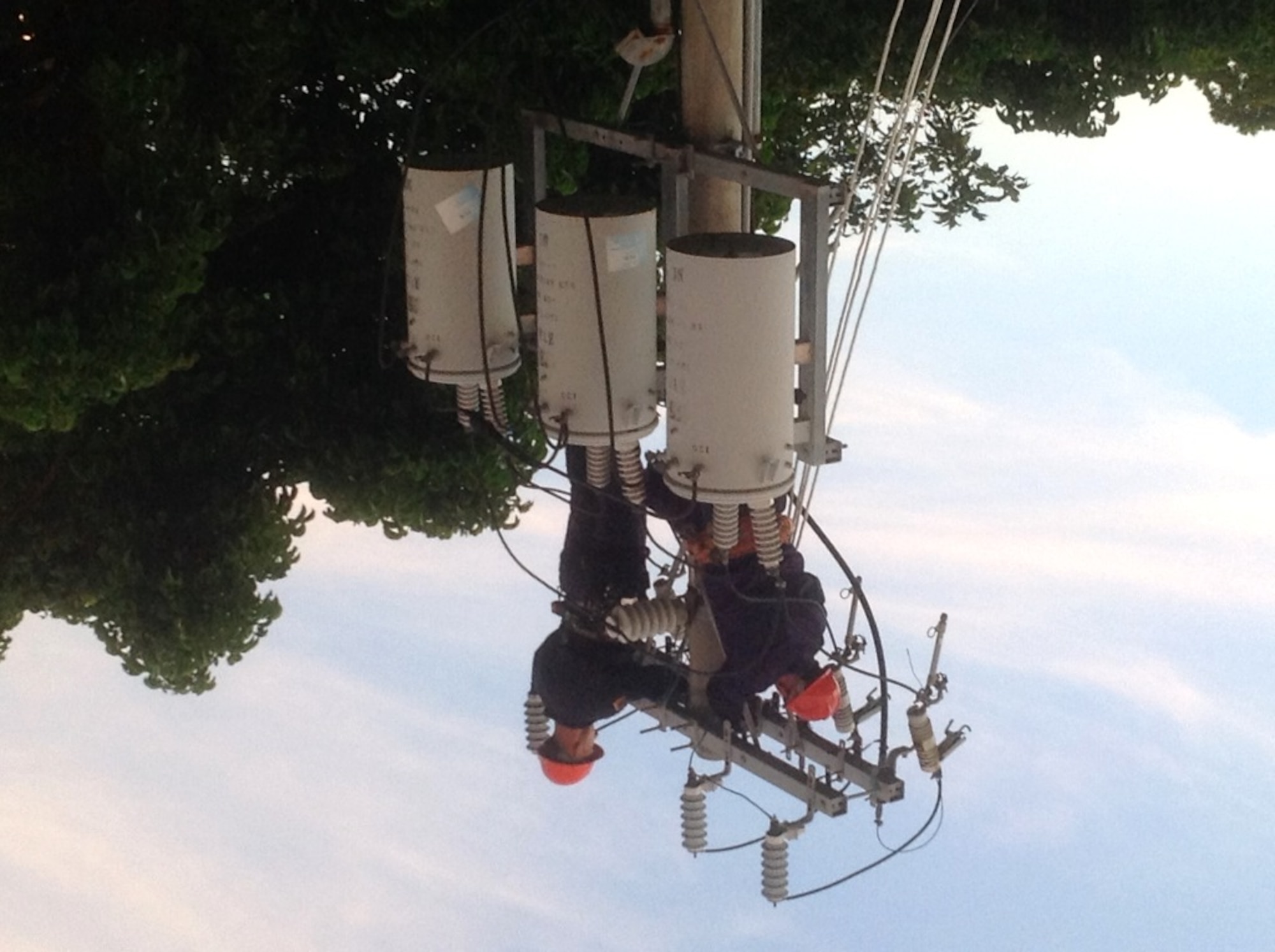 U.S. Air Force Airman 1st Class Christian Rosa, (left), and Staff Sgt. Nicholas Scheerer, (right), 18th Civil Engineer Squadron electrical systems technicians, work on an overhead power line on Kadena Air Base, Japan, Sept. 14, 2014. The 18th CES has been working on converting all of the overhead lines to underground lines. (Courtesy photo by 18th CES)  