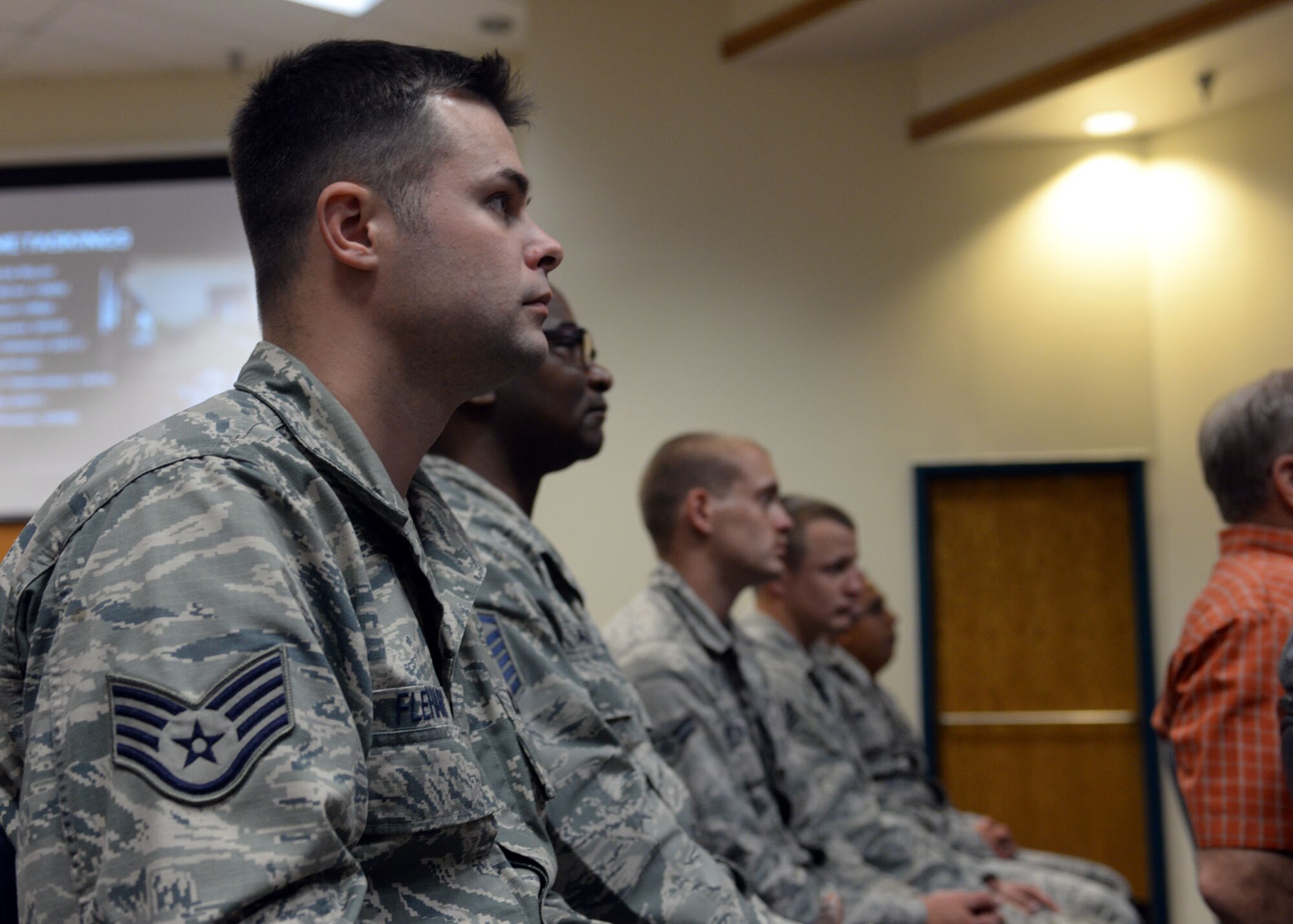 ALTUS AIR FORCE BASE, Okla. – U.S. Air Force Airmen from the 97th Air Mobility Wing watch a video during a 97th Civil Engineer Squadron heritage brief at the Freedom Community Center, Oct. 1, 2014. The video showcased some of civil engineering’s earliest missions as Prime Base Engineering Emergency Force and Rapid Engineer Deployable Heavy Operational Repair Squadron Engineer units. (U.S. Air Force photo by Senior Airman Franklin R. Ramos/Released)