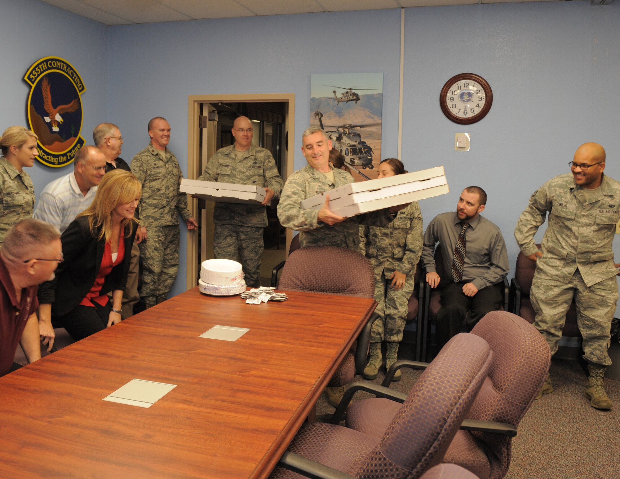 U.S. Air Force Col. Stephen Renner, 355th Fighter Wing vice commander, and Chief Master Sgt. Ryan Peterson, 355th FW command chief master sergeant, deliver pizza to the 355th Contracting Squadron at Davis-Monthan Air Force Base, Ariz., Sept. 30, 2014. Renner and Peterson delivered the pizza as a token of thanks to the 355th CONS for working through the evening and into the early morning hours. The objective of the extended work day was to award as many contracts as possible before the end of Air Force fiscal year 2014. (U.S. Air Force photo by Airman 1st Class Chris Drzazgowski/Released)