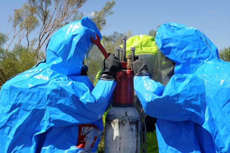U.S. Air Force Airman 1st Class Dylan Bivens and John Schaeffer, 355th Civil Engineering Squadron readiness and emergency management apprentices, and Staff Sgt. Ashley Jordan, 355th Aerospace Medicine Squadron bioenvironmental engineering technician, utilize a chlorine kit to secure a leaking 150 pound chlorine cylinder during a Multi-Agency HAZMAT Exercise at Davis-Monthan Air Force Base, Ariz., Sept. 29, 2014. The kit is designed to prevent further release from the cylinder and limit contamination. (U.S. Air Force photo by Airman 1st Class Cheyenne Morigeau/Released)

