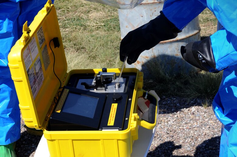 U.S. Air Force Airman 1st Class John Schaeffer, 355th Civil Engineering Squadron readiness and emergency management apprentice, uses a HAZMAT ID to identify the hazardous material found in a leaking 55 gallon drum during a Multi-Agency HAZMAT Exercise at Davis-Monthan Air Force Base, Ariz., Sept. 29, 2014. The HAZMAT ID is a portable solid and liquid identifier that uses Fourier transform infrared spectroscopy to identify chemicals, warfare agents, explosives, pesticides, and suspicious powders.  (U.S. Air Force photo by Airman 1st Class Cheyenne Morigeau/Released)