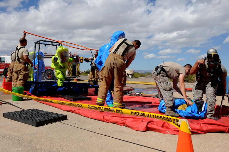 Responders from the Bioenvironmental Engineering and Emergency Management flights proceed through a decontamination zone following operations in a simulated contaminated area at Davis-Monthan Air Force Base, Ariz., Sept. 29, 2014.  Decontamination is an essential element of handling hazardous materials because it minimizes the spread of contaminants to both personnel and equipment. This training showcased the expertise and resources that are available to D-M leadership in the event of a real-world incident involving hazardous materials.  (U.S. Air Force photo by Airman 1st Class Cheyenne Morigeau/Released)