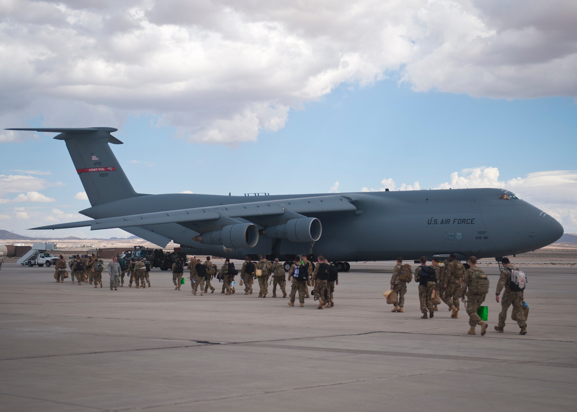 Airmen from the 58th Rescue Squadron, 66th Rescue Squadron and 823rd Maintenance Squadron prepare to board a C-5 Galaxy for a deployment in Southwest Asia at Nellis Air Force Base, Nev., Sept. 26, 2014. These Airmen will support real-world operations in the region during their time overseas. (U.S. Air Force photo by Staff Sgt. Siuta B. Ika)